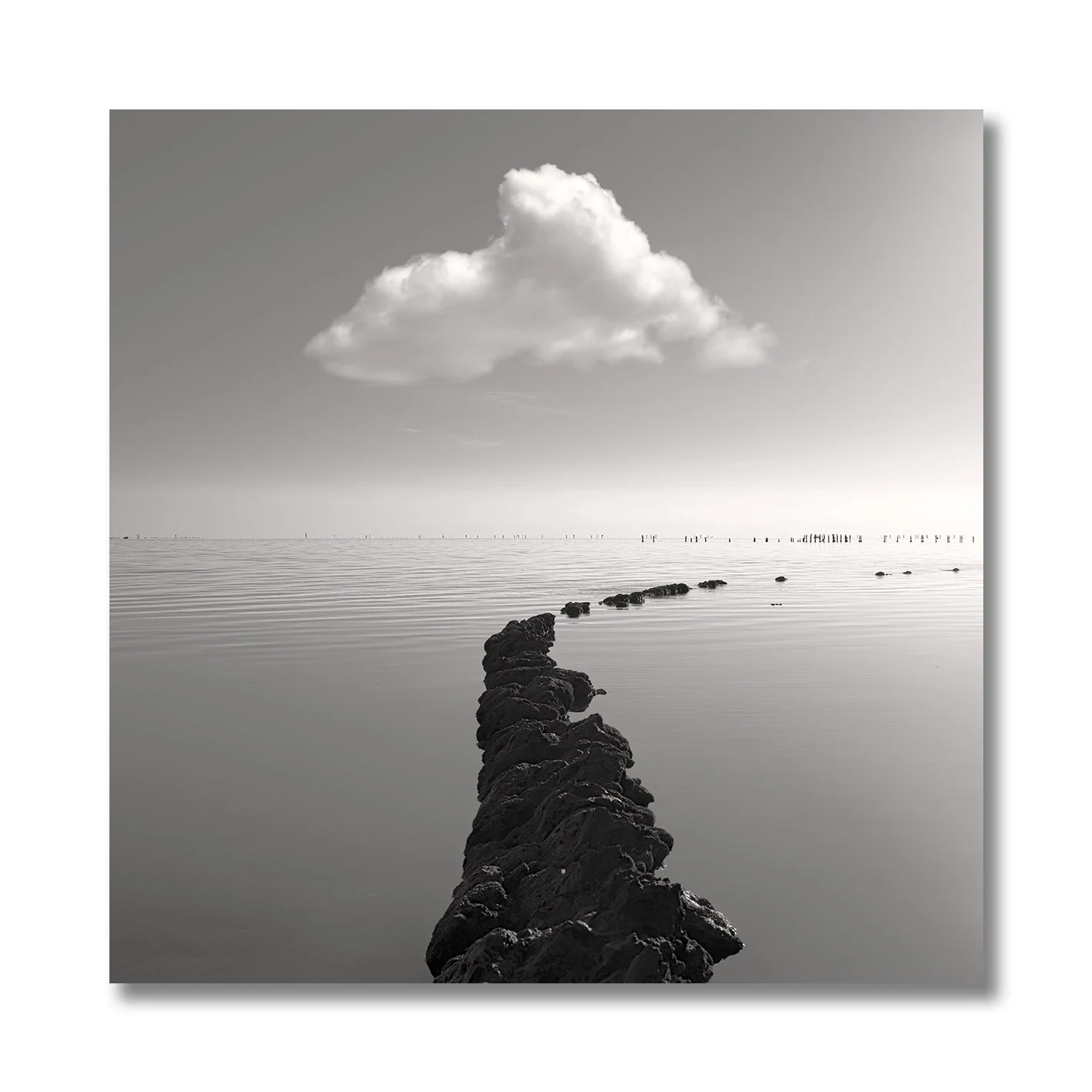 Black and white fine art photograph of calm water and curved rock formation