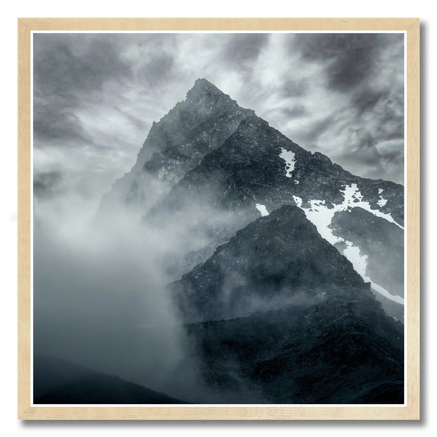 Mountain photograph emerging through mist and cloud with rugged alpine peak