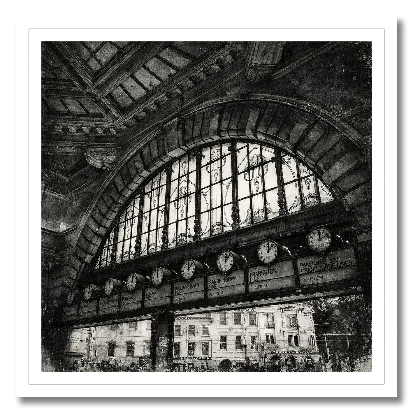 Black and white photograph of Flinders Street Station clocks under arched window