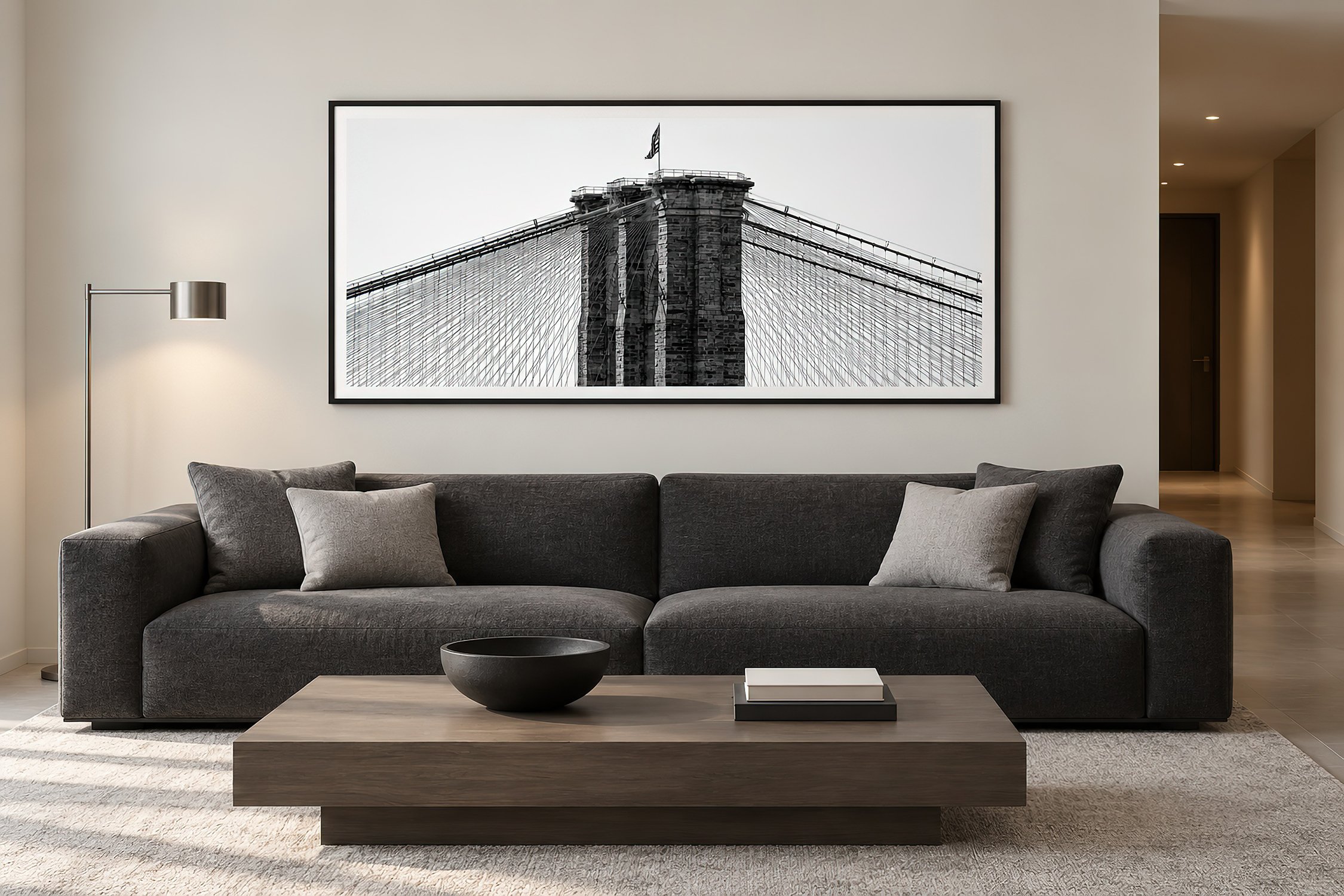 Brooklyn Bridge black and white photography print in a black frame above a charcoal sofa.