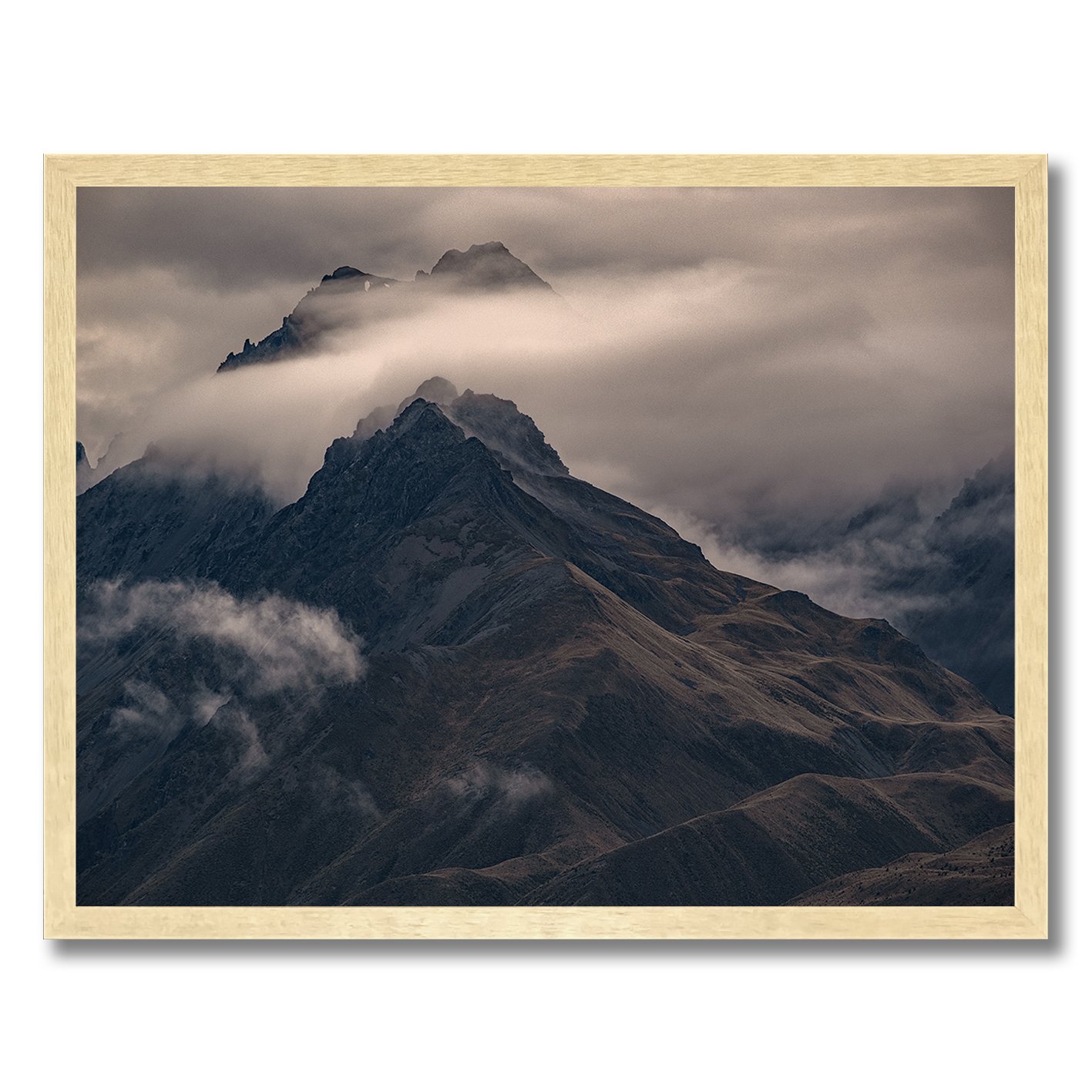 Moody mountain photograph with mist drifting across dark alpine ridges