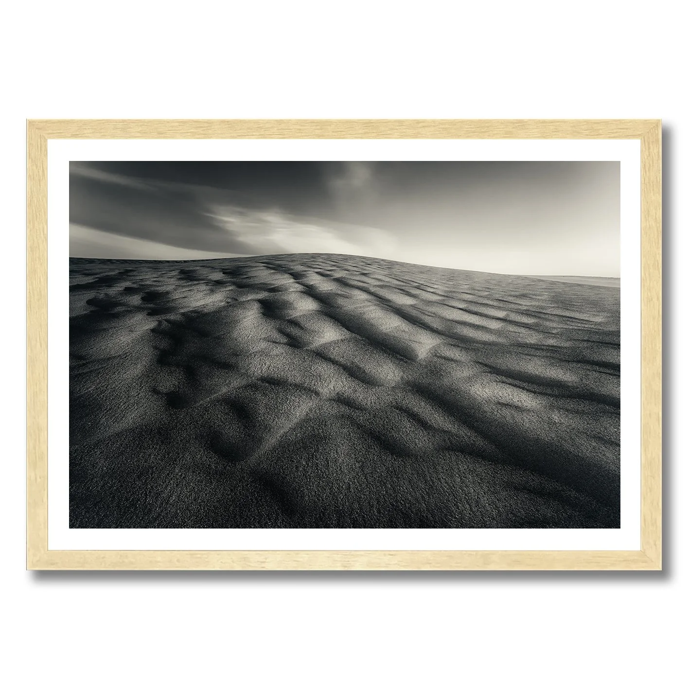 Black and white photograph of sculpted sand dunes with flowing ripples and dramatic shadows.