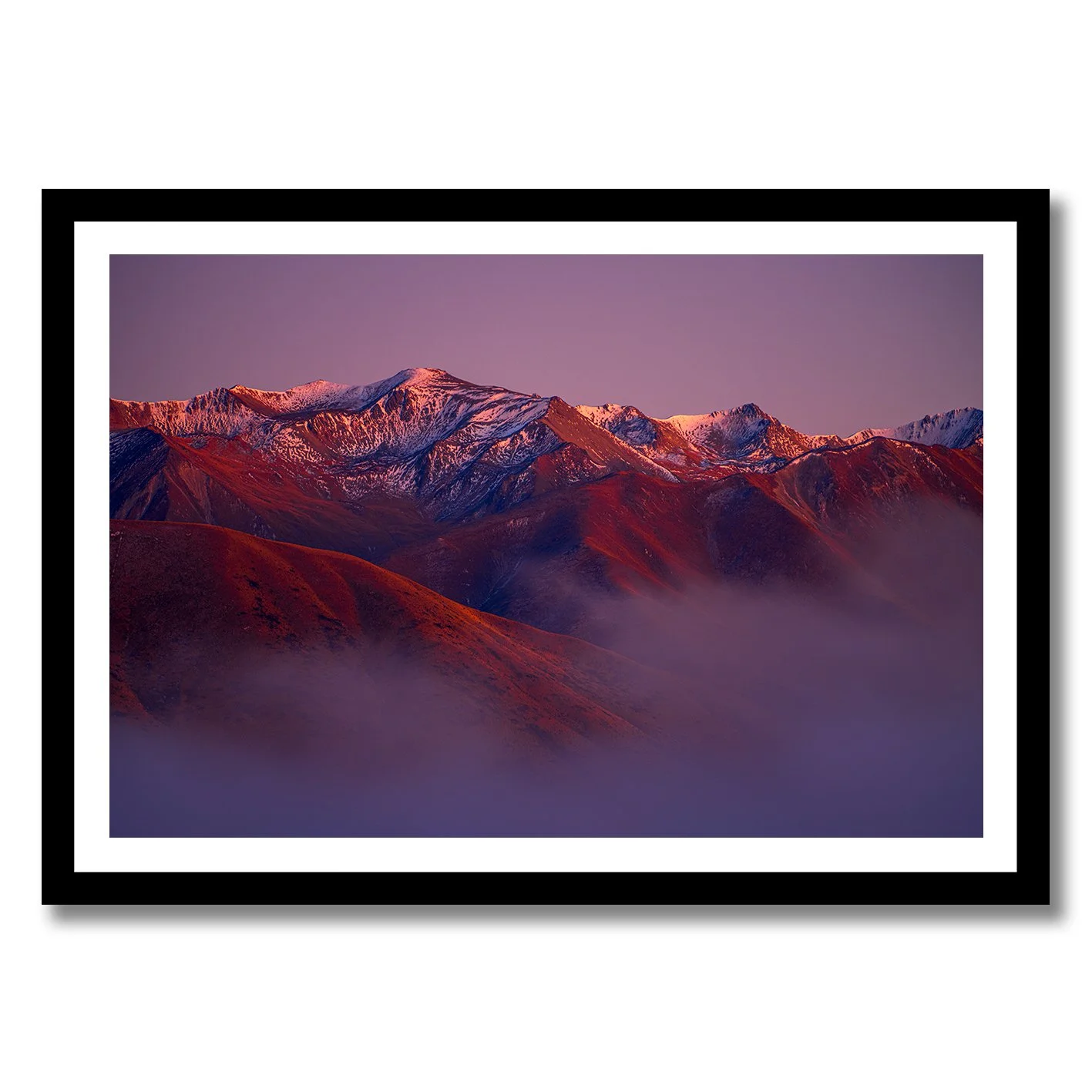 Mountain landscape photograph with alpenglow light on snowy peaks and misty valleys