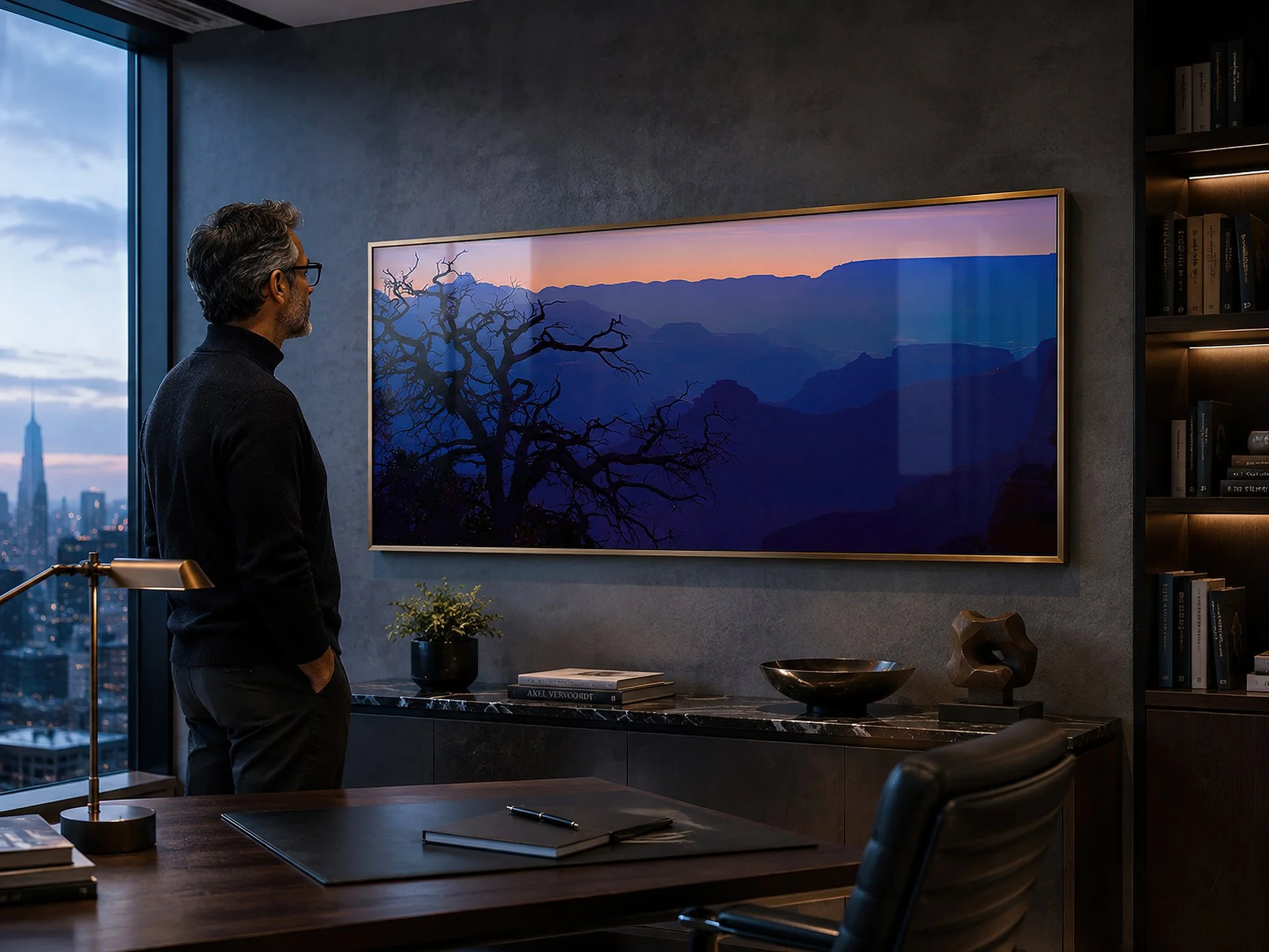 Framed Grand Canyon dawn photograph displayed behind reflective glass in a sophisticated modern office with a man standing nearby.