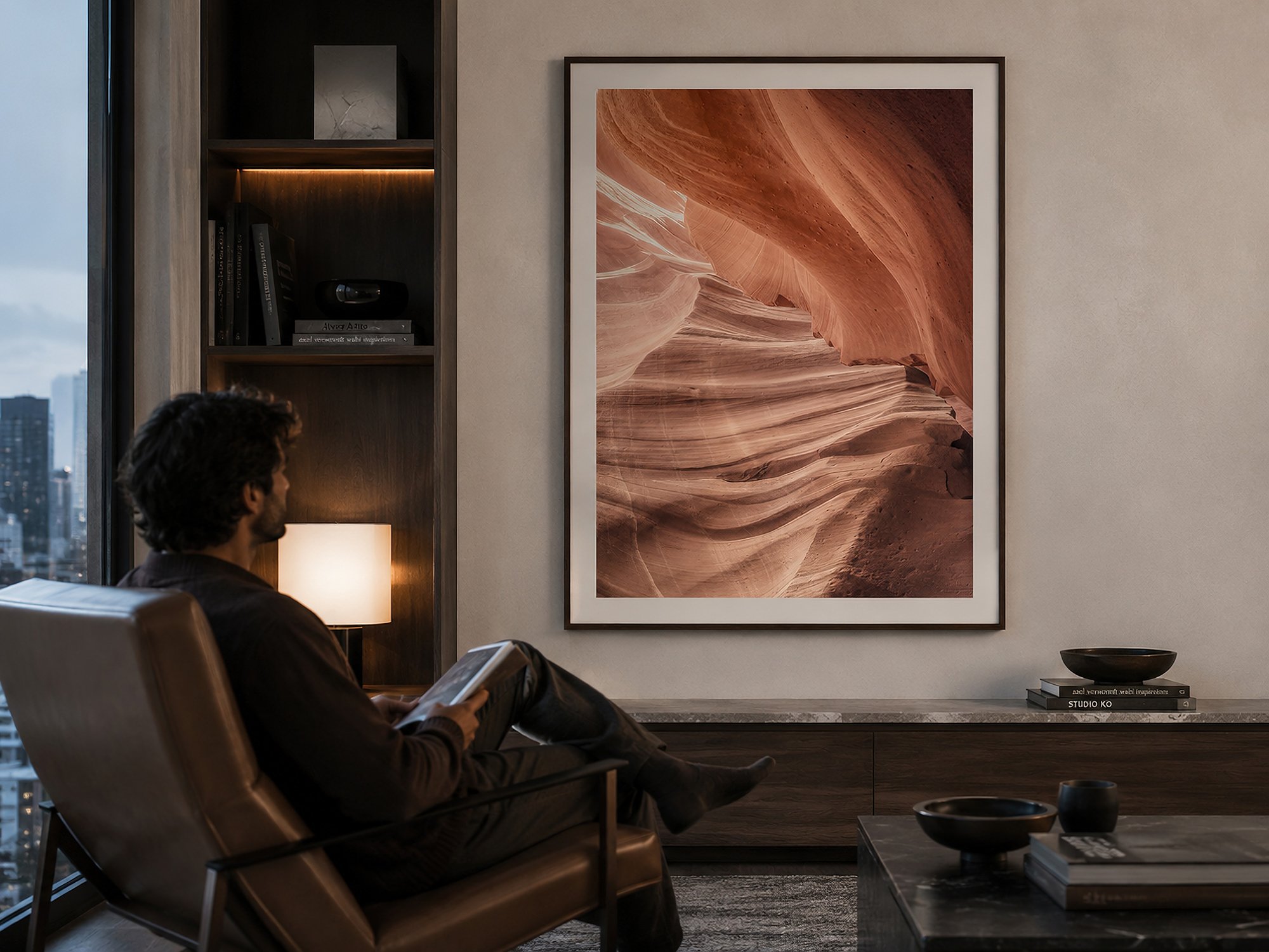 Framed Antelope Canyon photograph displayed in a modern city apartment with a seated man reading nearby.