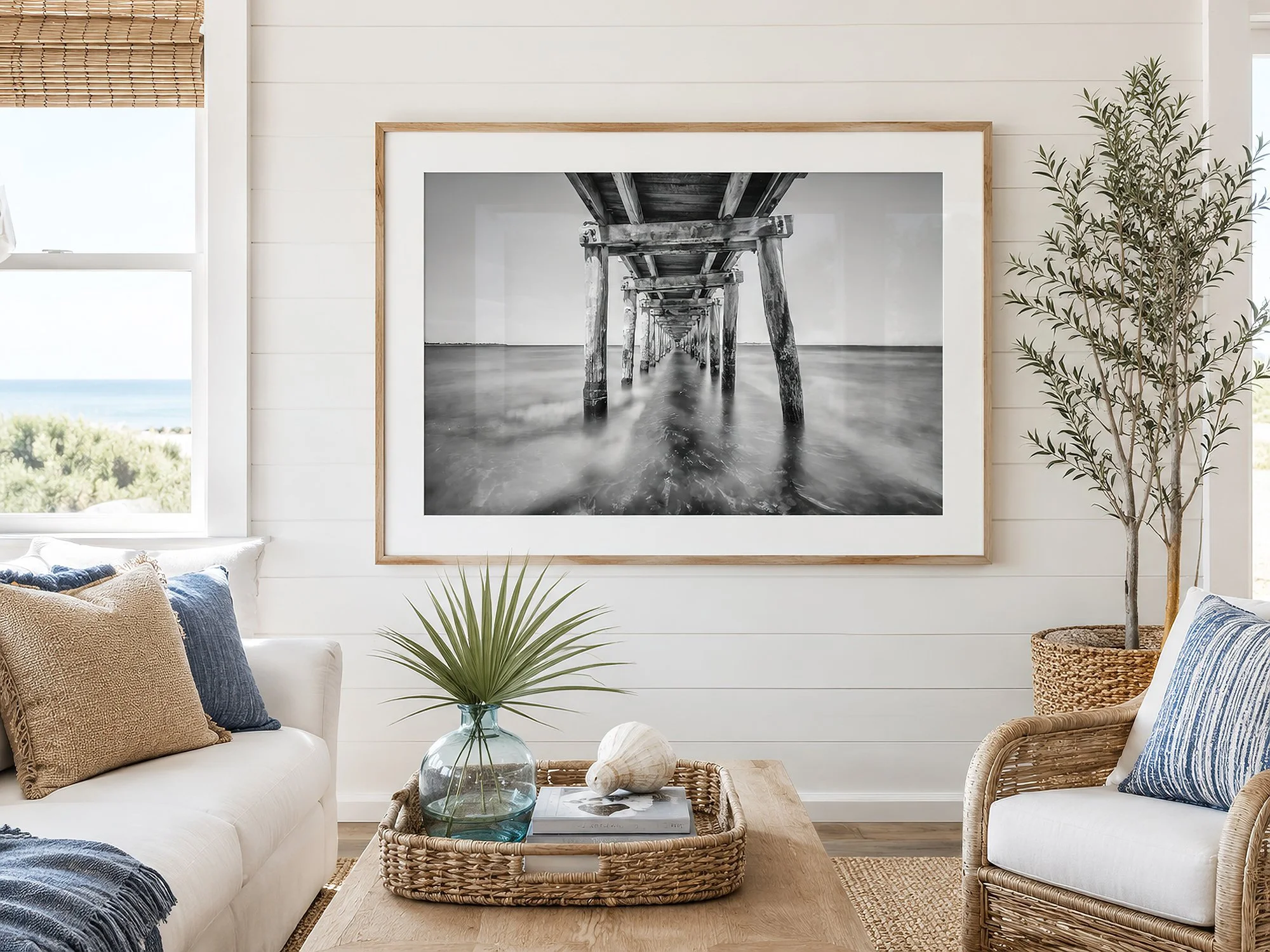 Bright coastal living room featuring a framed black and white photograph beneath Point Lonsdale Pier, styled with natural timber, woven textures and ocean views, by Nick Psomiadis at NIKART Studio and Gallery.