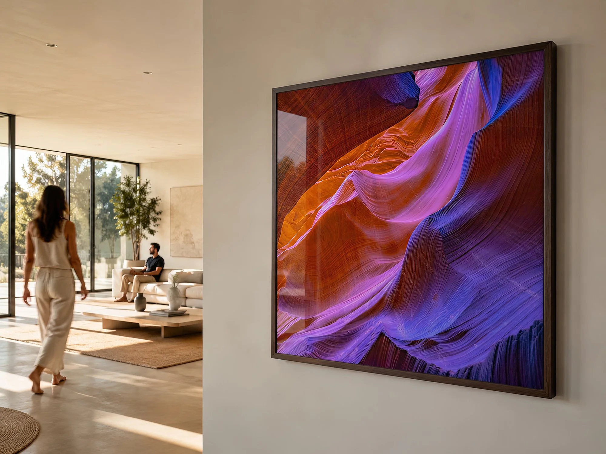 Sunlit modern living room with a close-up dark-framed Antelope Canyon photograph and two people in the background by Nick Psomiadis at NIKART Studio and Gallery