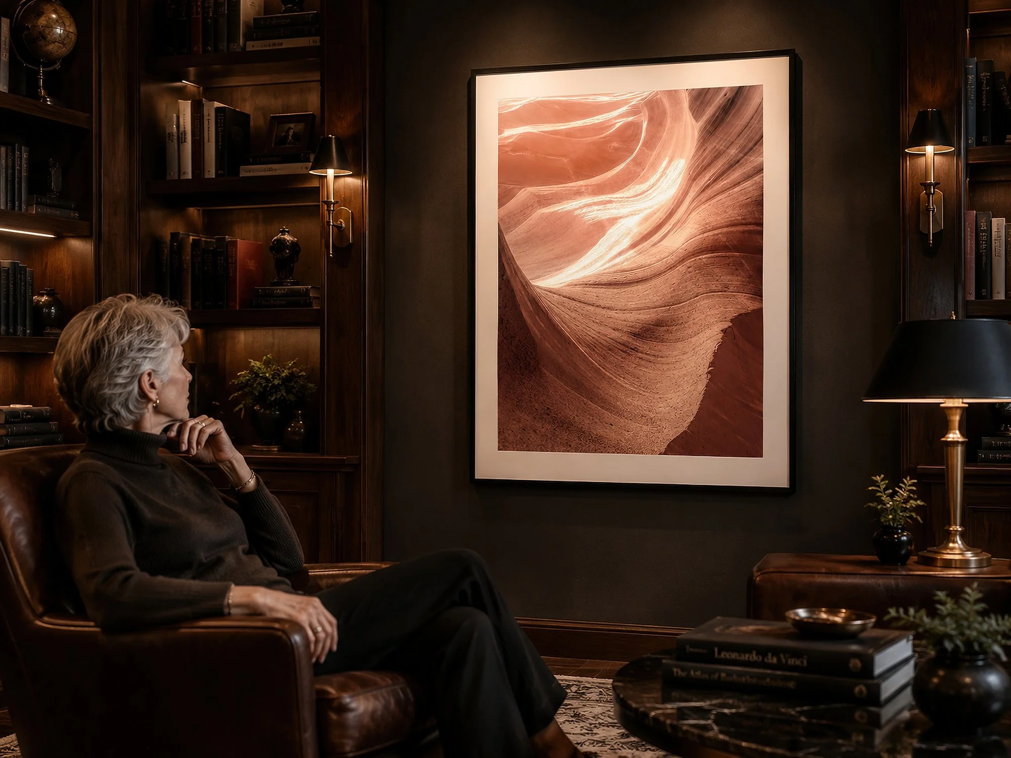 Framed Antelope Canyon photograph displayed in a warmly lit private library with a seated older woman.