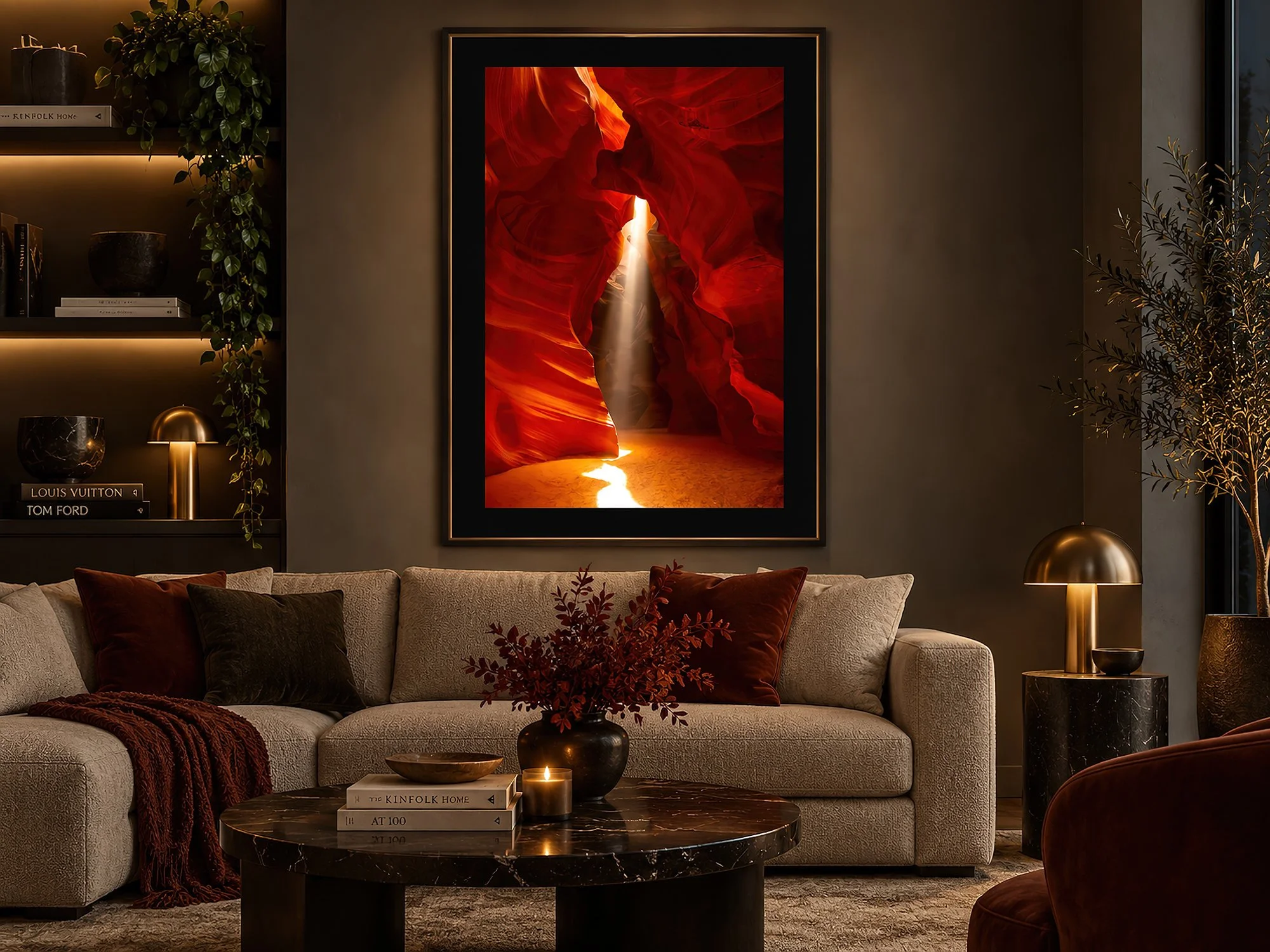Framed slot canyon photograph with vivid red sandstone and a glowing sunbeam, displayed above a sofa in a moody lounge interior by Nick Psomiadis at NIKART Studio and Gallery