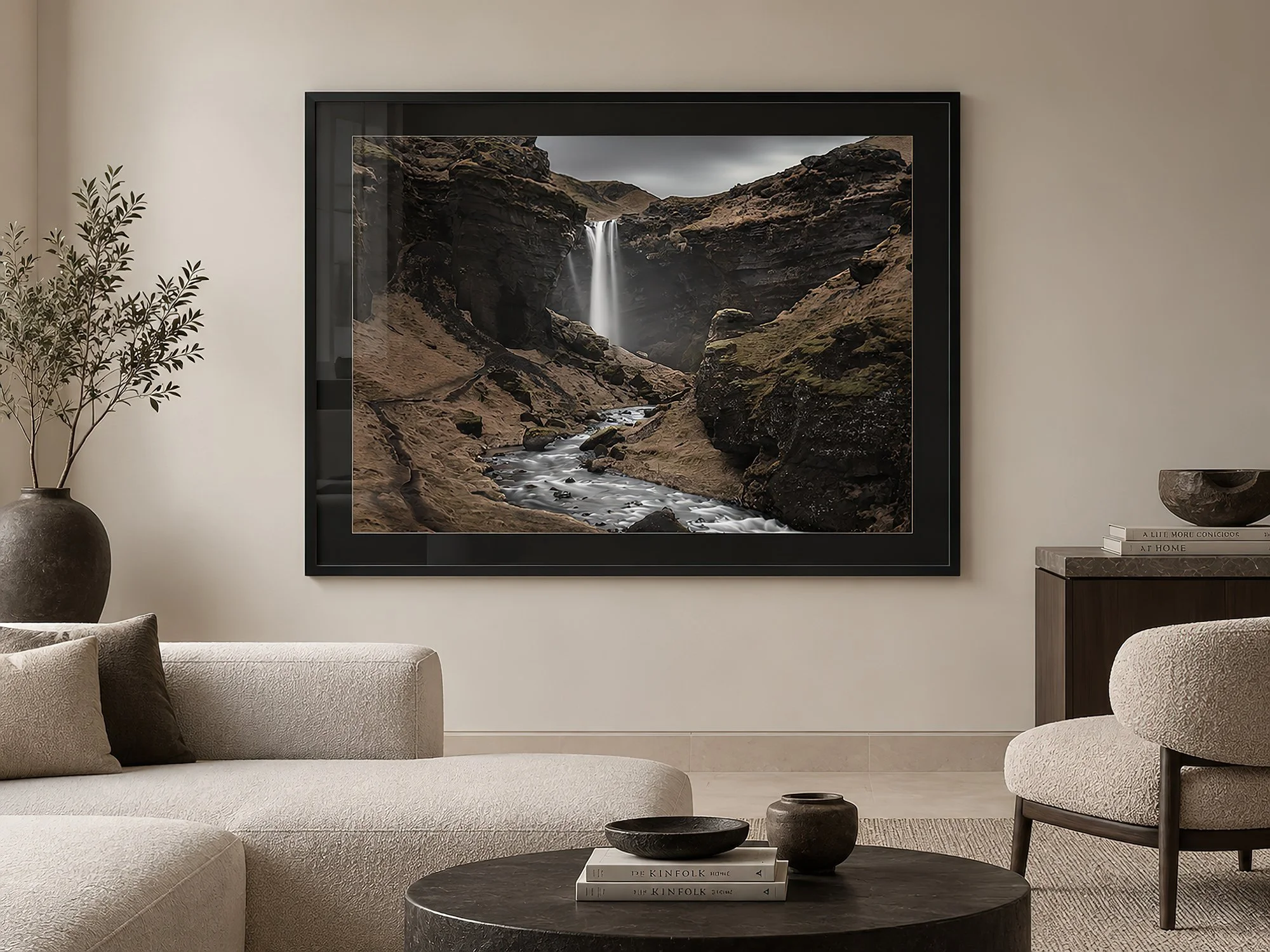 Moody Iceland waterfall photograph in a luxury black frame with black mat, displayed in a minimalist contemporary living room with neutral furnishings, by Nick Psomiadis at NIKART Studio and Gallery