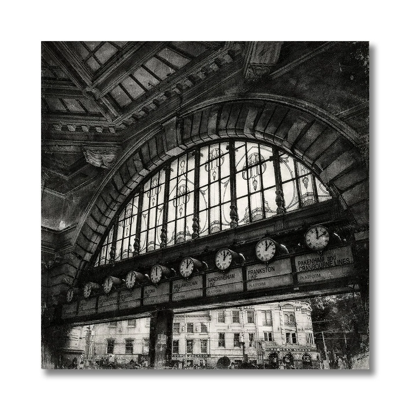 Black and white photograph of Flinders Street Station clocks under arched window
