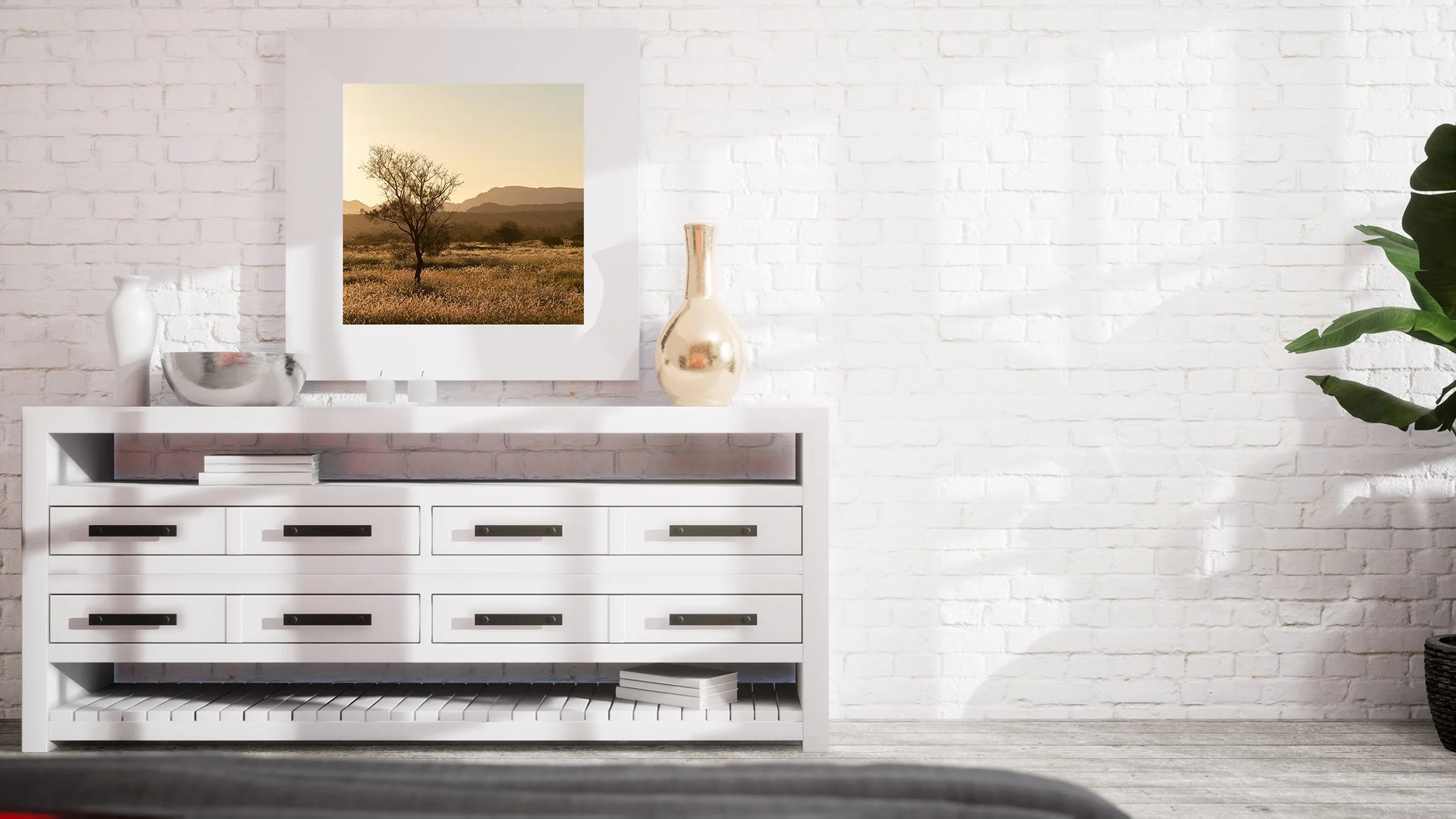 Golden hour photograph of an Australian outback grass plain with a lone tree and mountain backdrop