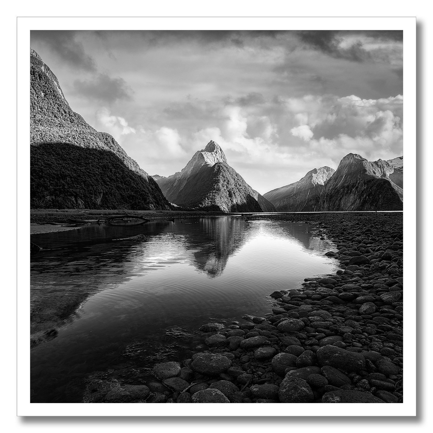 black and white photograph of mitre peak at milford sound with calm reflection