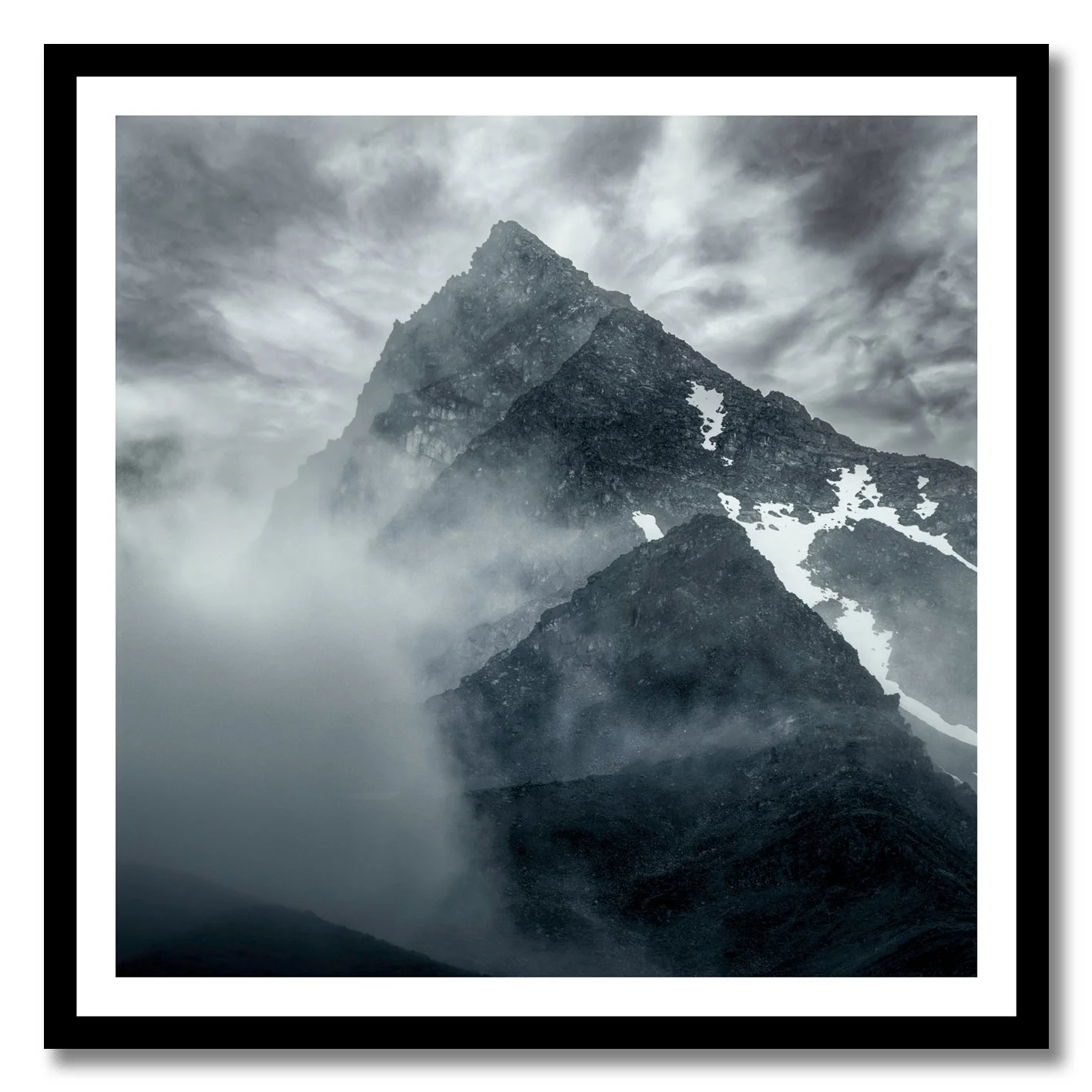 Mountain photograph emerging through mist and cloud with rugged alpine peak