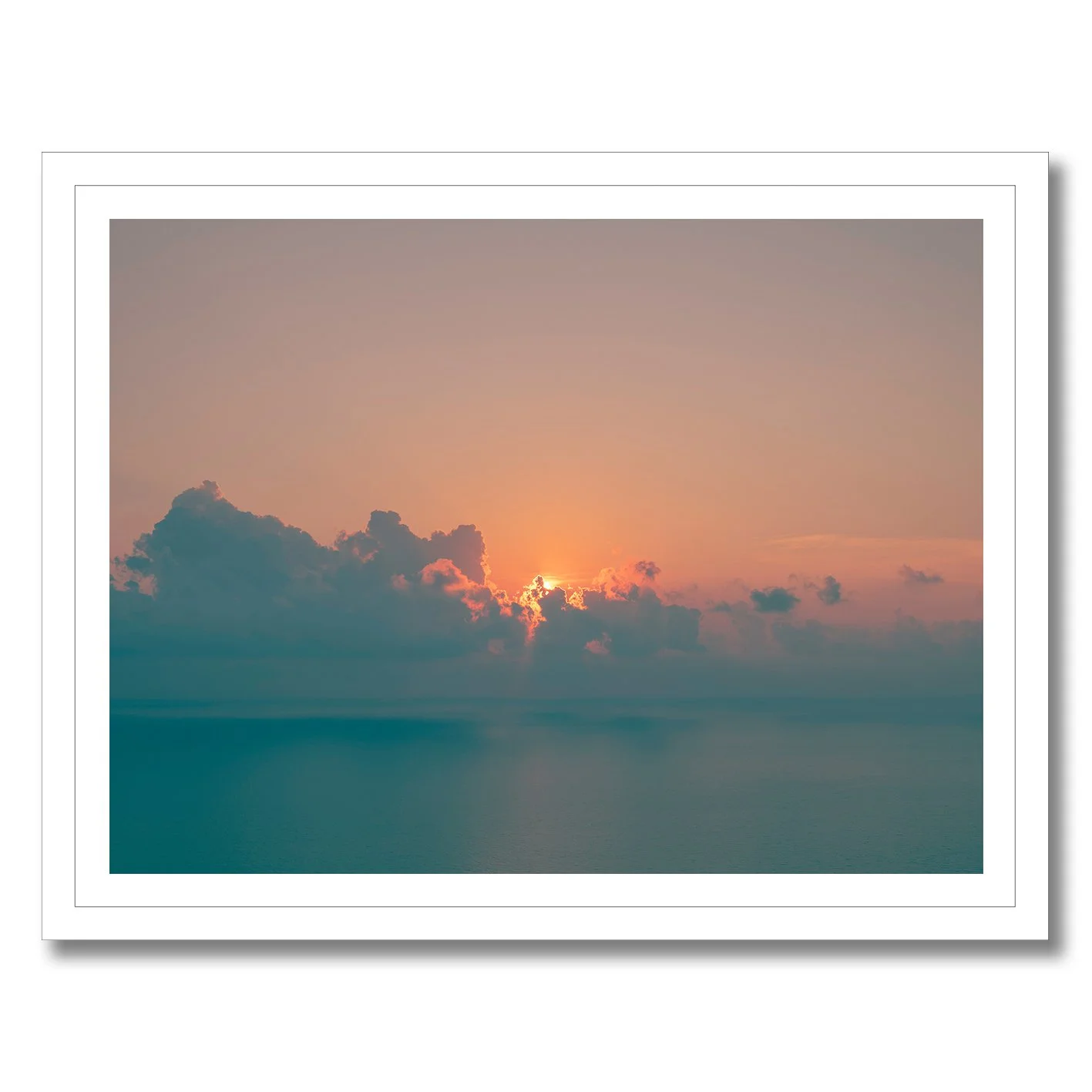 Sunrise seascape photograph with glowing horizon and soft clouds over calm ocean