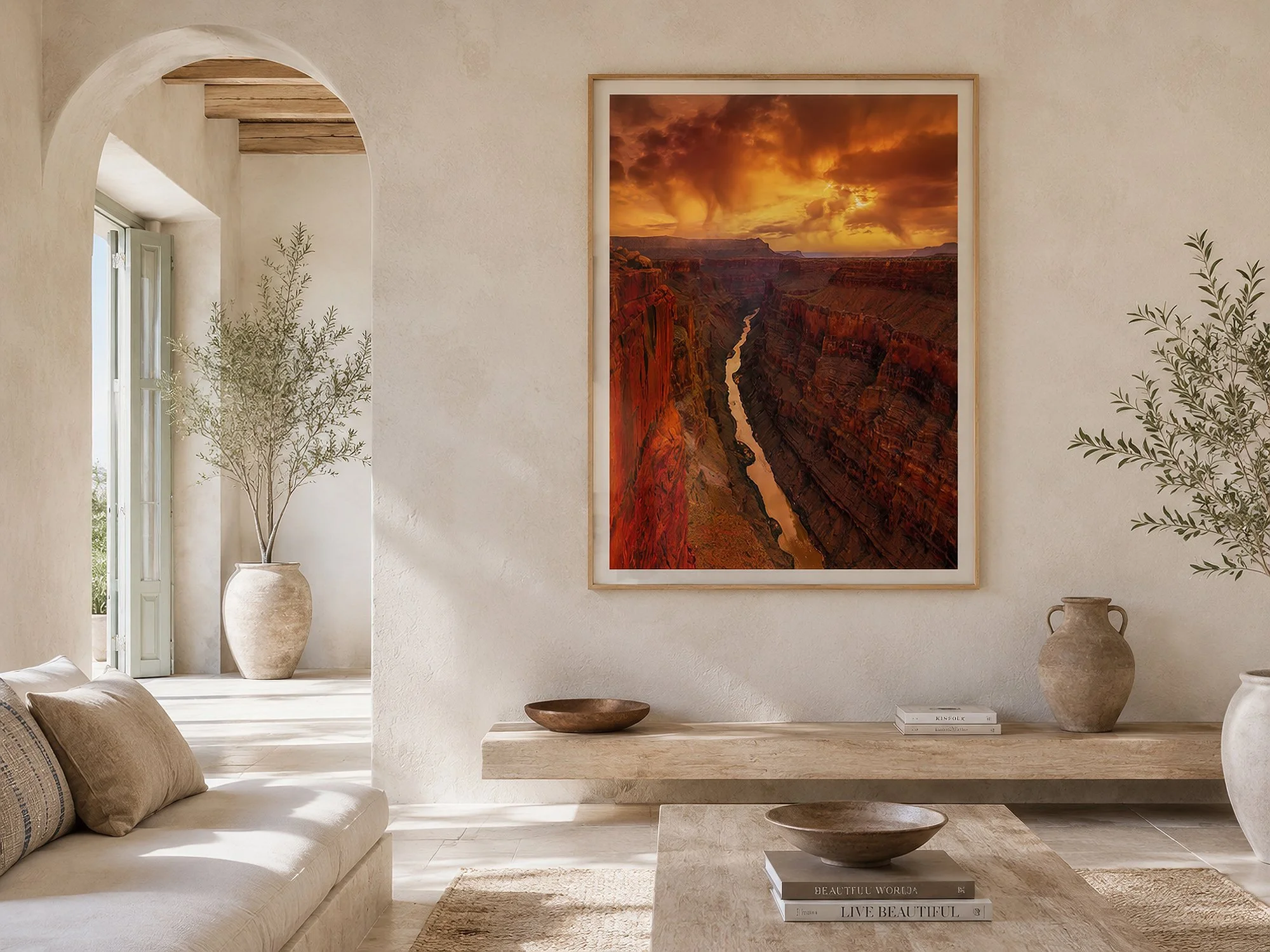 Framed Toroweap Grand Canyon photograph displayed in a bright Mediterranean-style living room with warm neutral décor and no people.