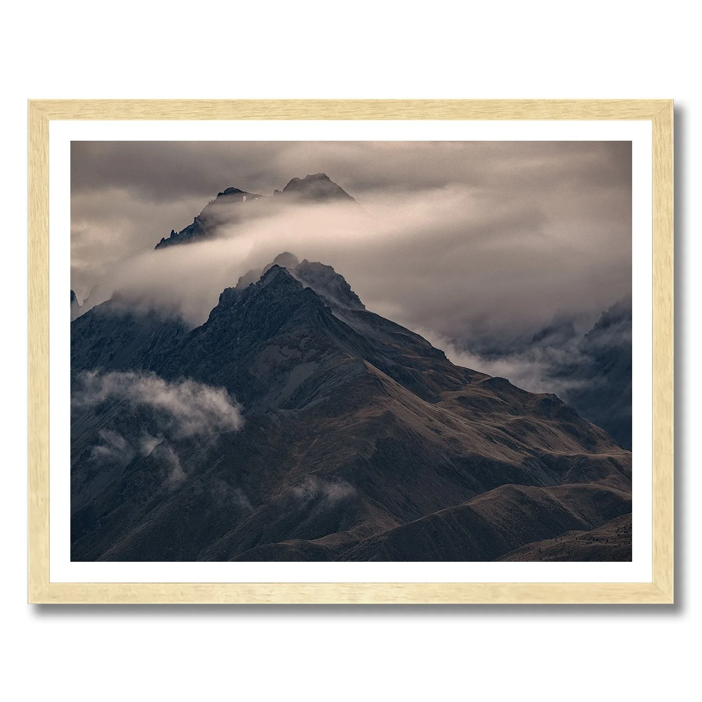 Moody mountain photograph with mist drifting across dark alpine ridges