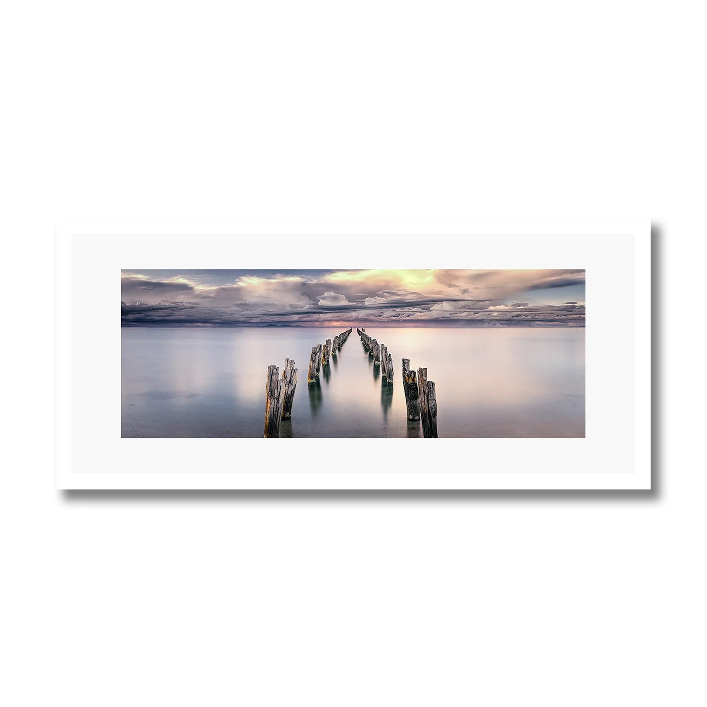 fine art photograph of weathered pylons in calm water at clifton springs under soft clouds