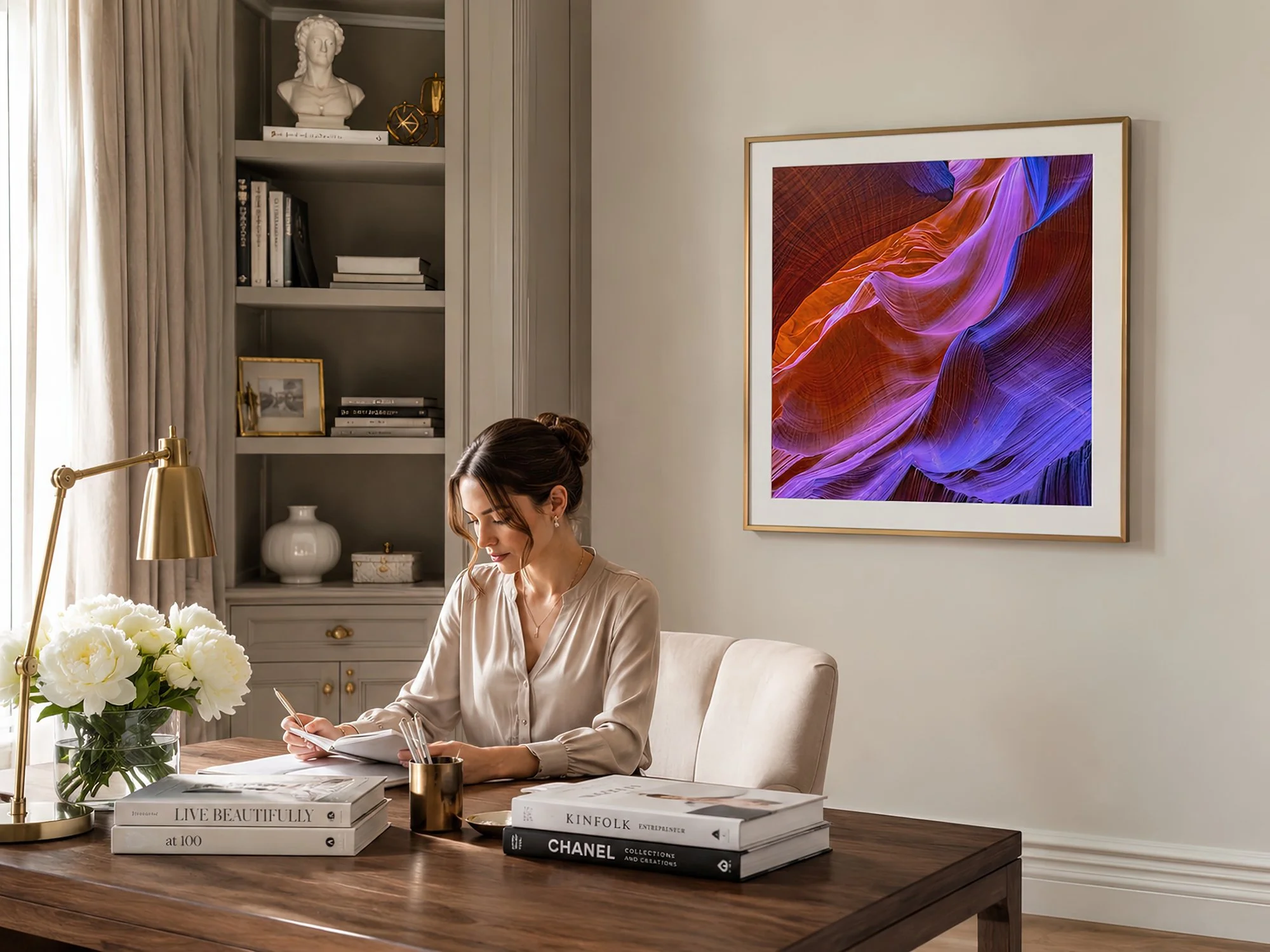 Elegant women’s study with a woman writing beside a gold-framed colourful Antelope Canyon photograph by Nick Psomiadis at NIKART Studio and Gallery