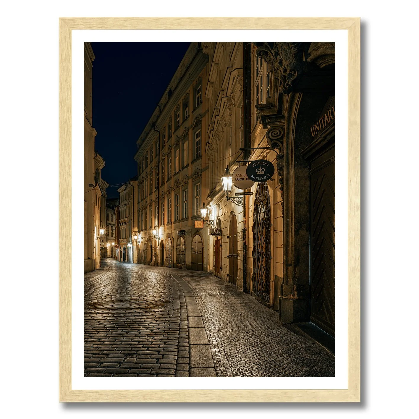 Night photograph of a quiet cobblestone street in Prague with warm lamps