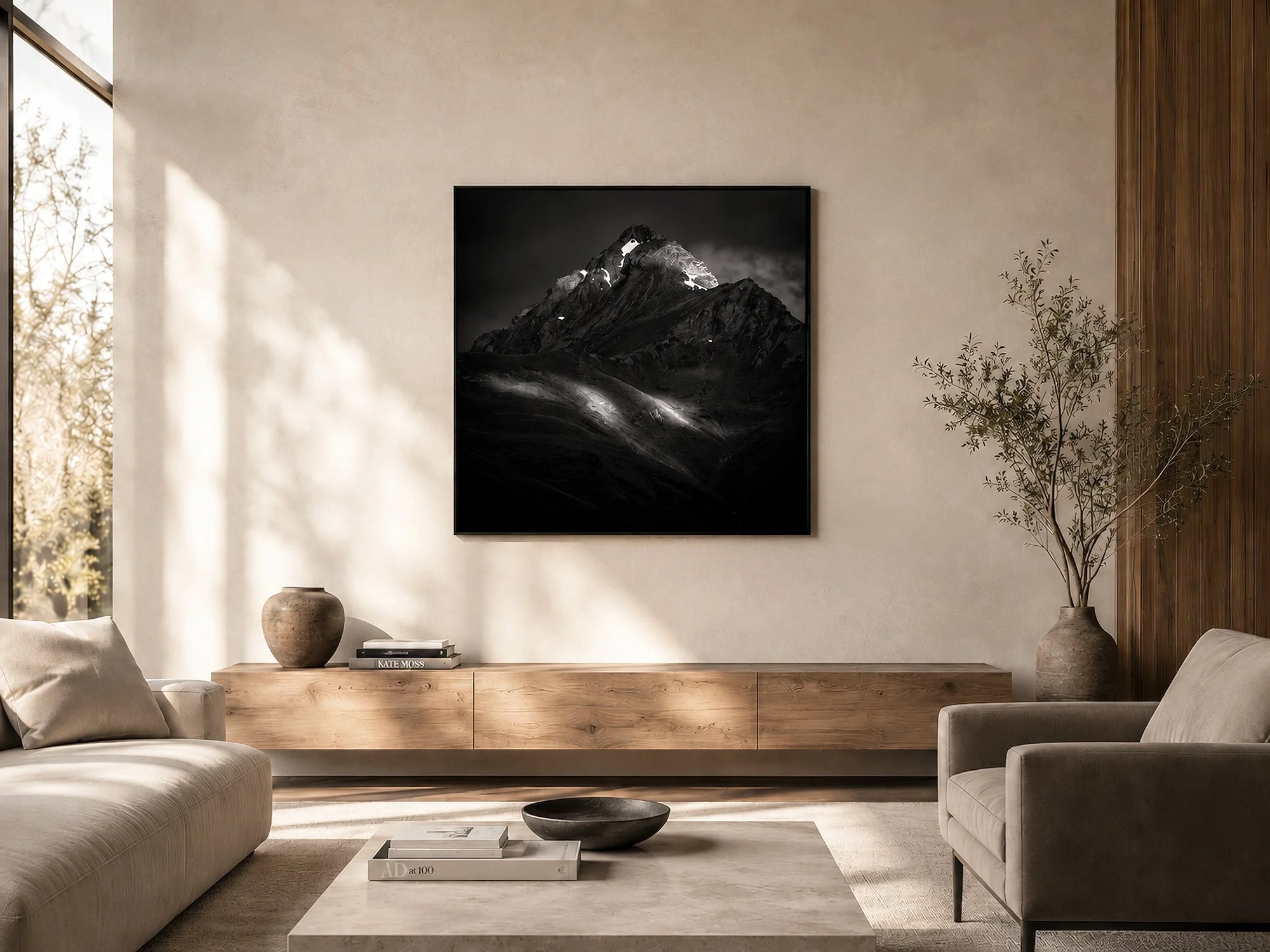 Square dark mountain photograph in a slim black frame, displayed above a timber console in a sunlit contemporary living room with neutral seating and minimalist décor by Nick Psomiadis at NIKART Studio and Gallery