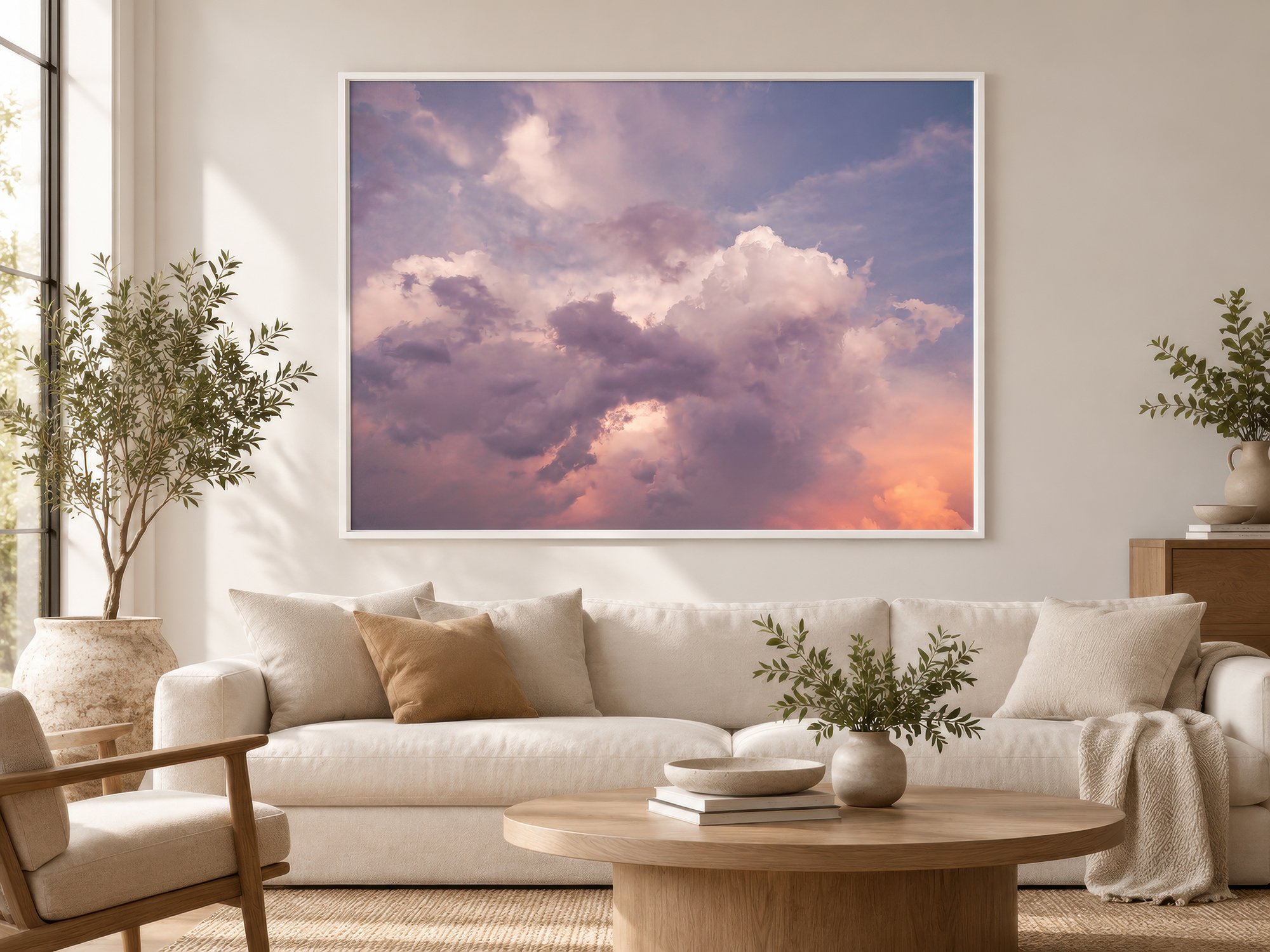 Large framed photograph of pastel sunset clouds above a cream sofa in a modern neutral living room by Nick Psomiadis at NIKART Studio and Gallery