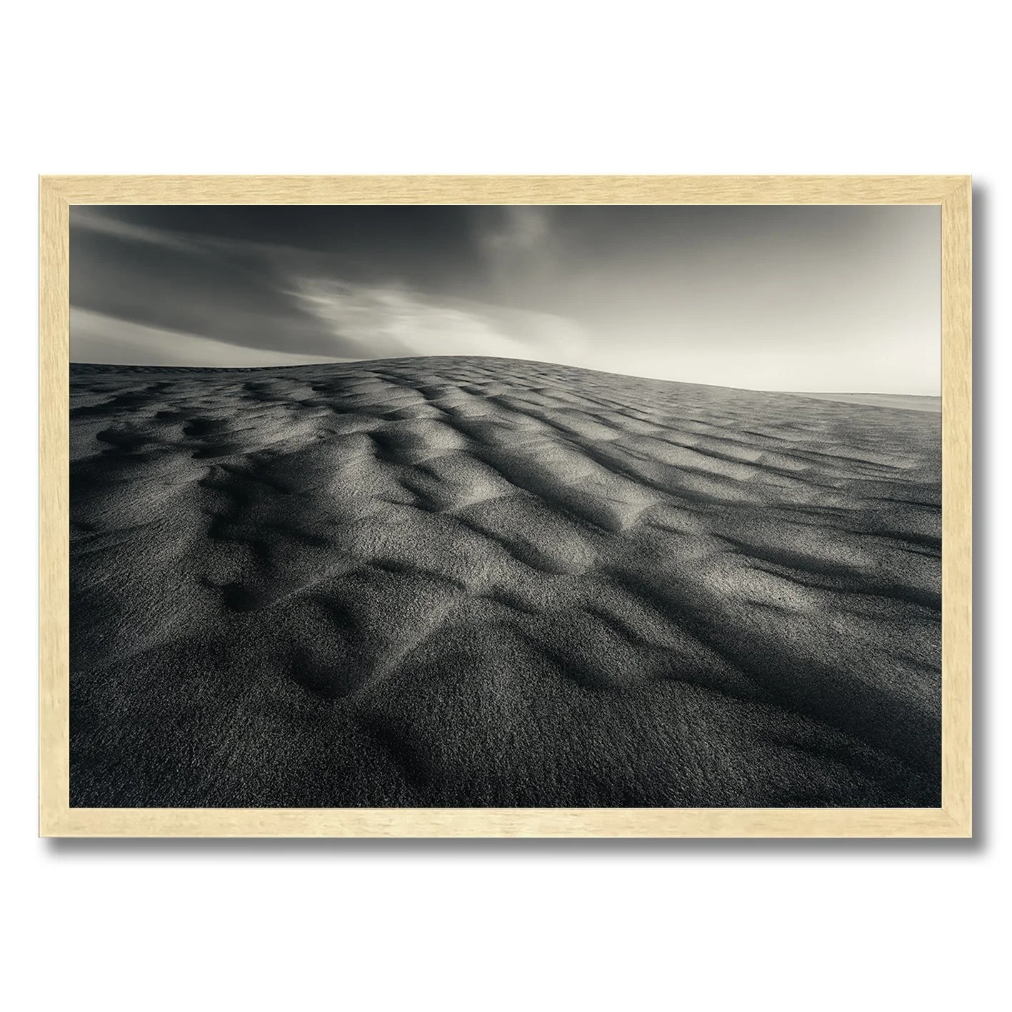 Black and white photograph of sculpted sand dunes with flowing ripples and dramatic shadows.