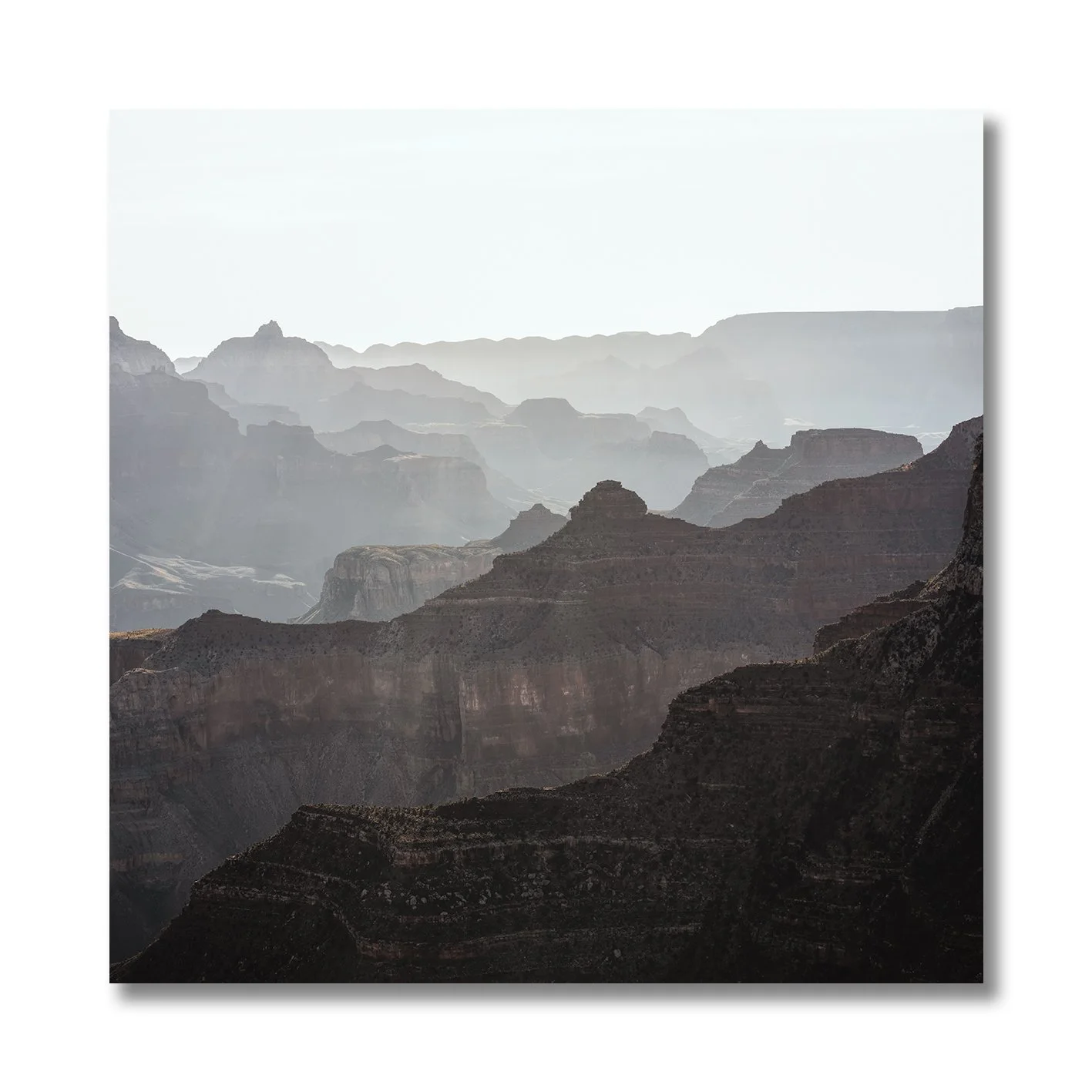 photograph of grand canyon arizona with layered rock formations and soft haze