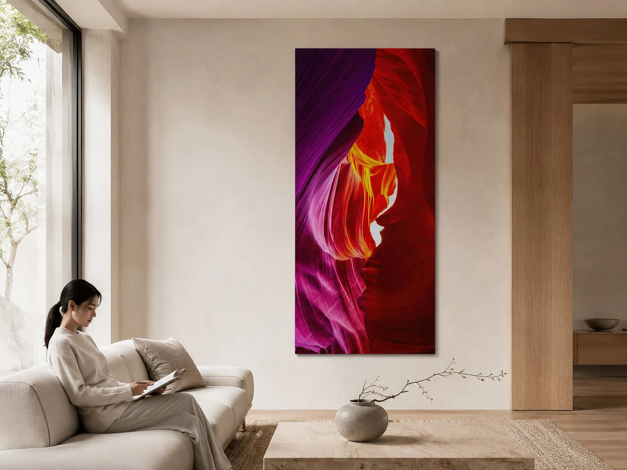 Tall colourful canyon canvas print in a minimalist living room with pale timber finishes, neutral seating, natural light and a woman reading on the sofa by Nick Psomiadis at NIKART Studio and Gallery