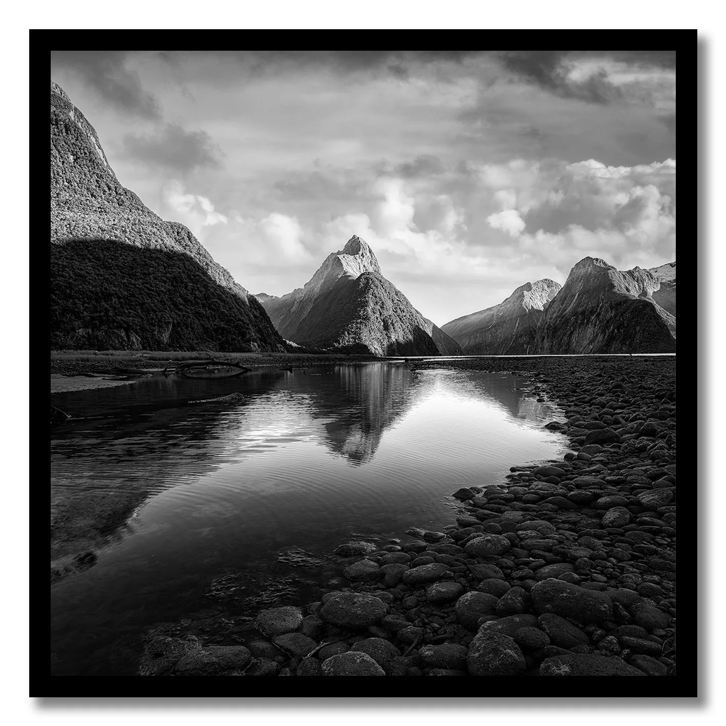 black and white photograph of mitre peak at milford sound with calm reflection