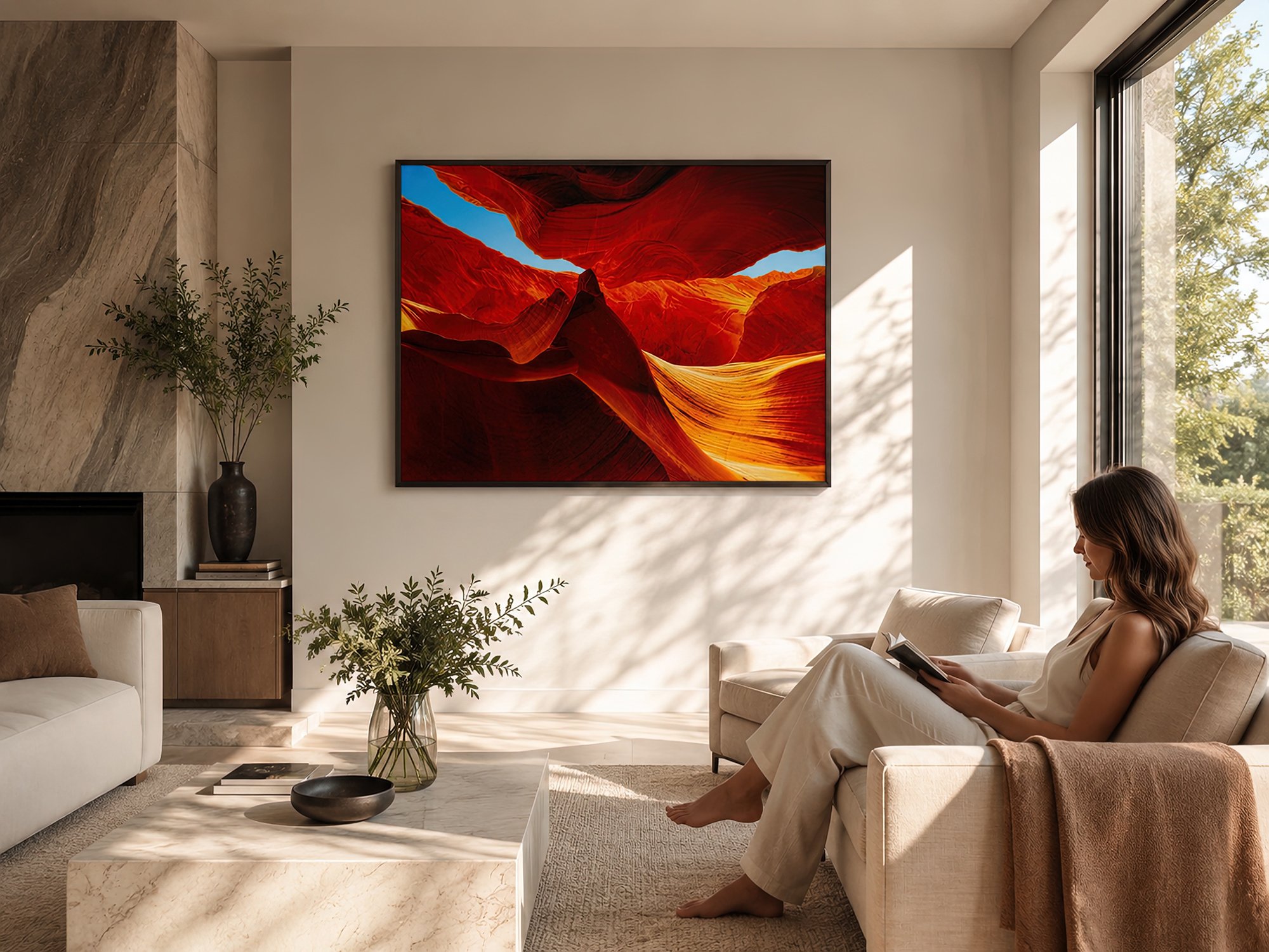 Sunlit contemporary living room with a seated woman reading beside a black-framed red Antelope Canyon photograph by Nick Psomiadis at NIKART Studio and Gallery