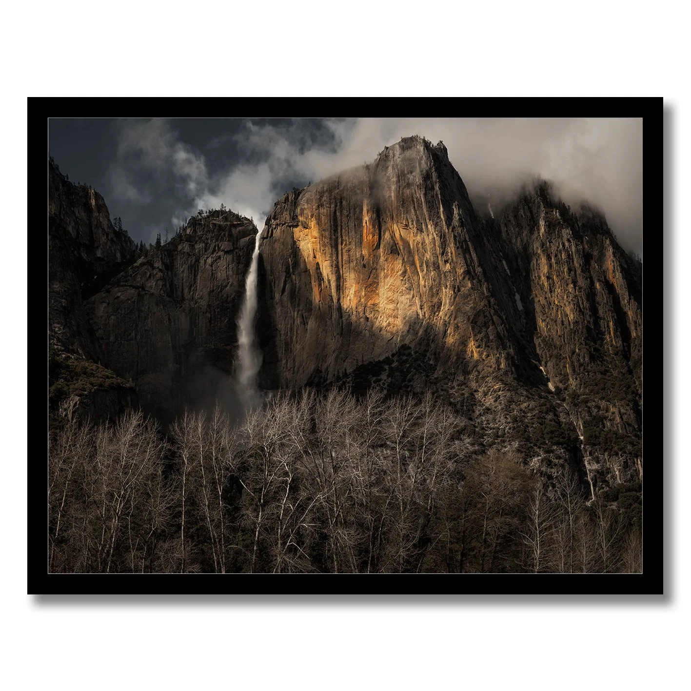 Yosemite Falls photograph with sunlit granite cliffs, mist and dark woodland in California