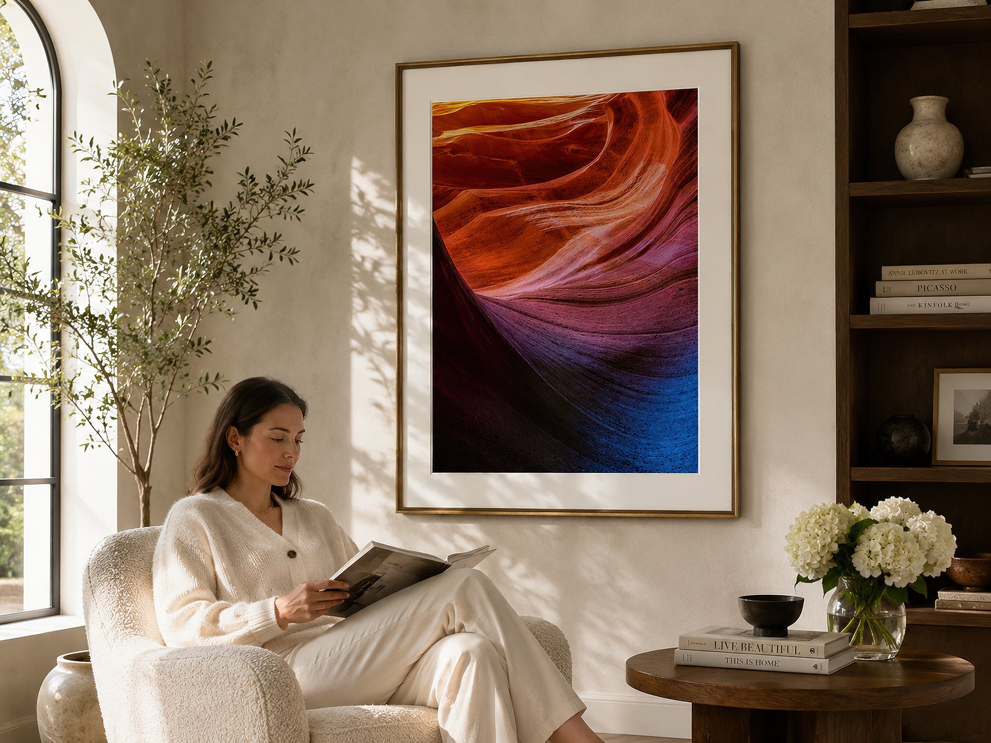 Framed Antelope Canyon photograph with an even white border displayed in a bright reading nook with a seated woman.