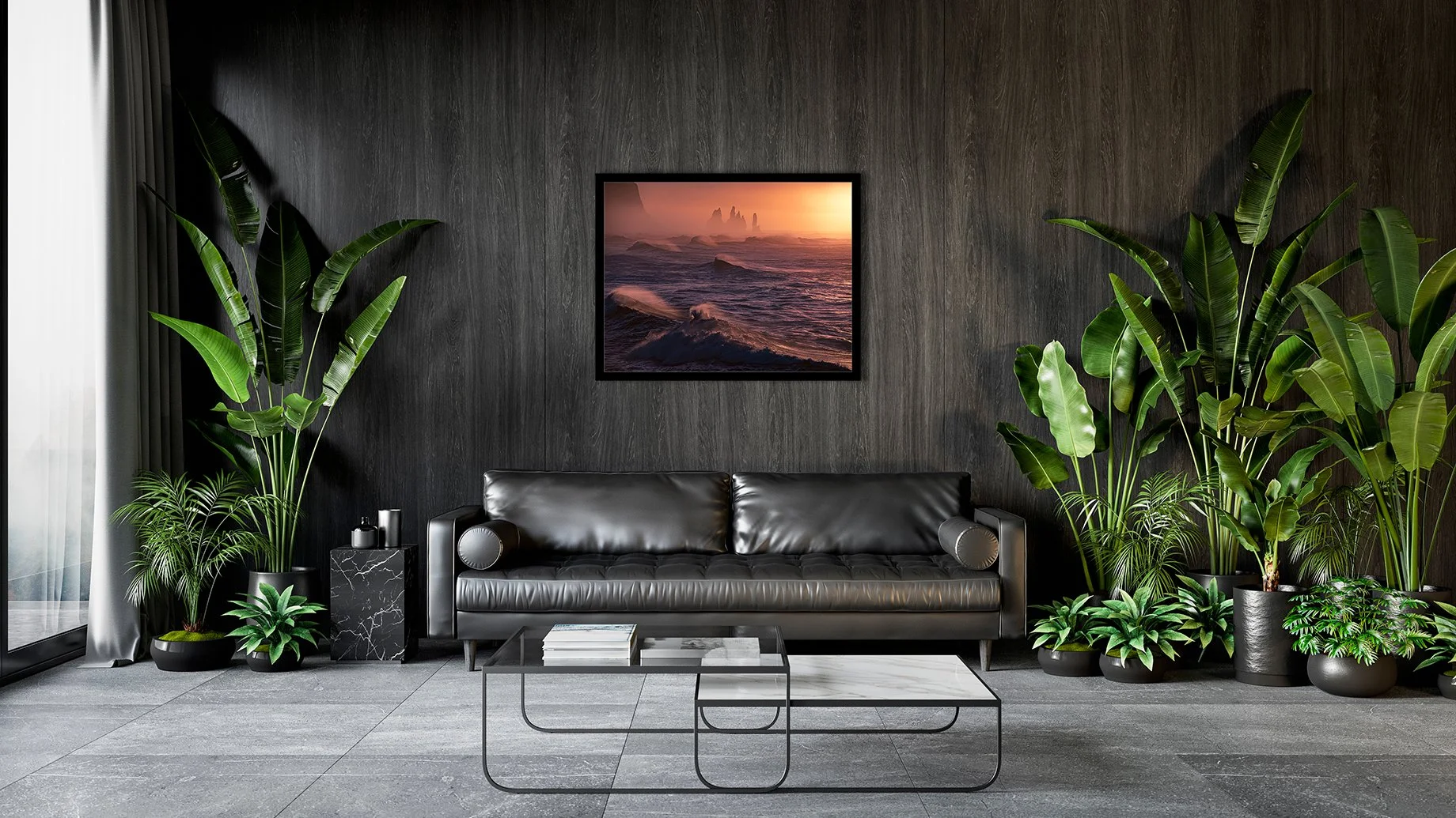 Modern living room with black leather sofa, large potted plants on either side, a framed artwork of ocean waves on the dark wooden wall, and a black coffee table with books.