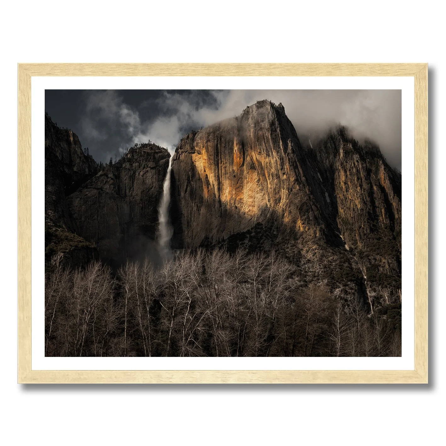Yosemite Falls photograph with sunlit granite cliffs, mist and dark woodland in California