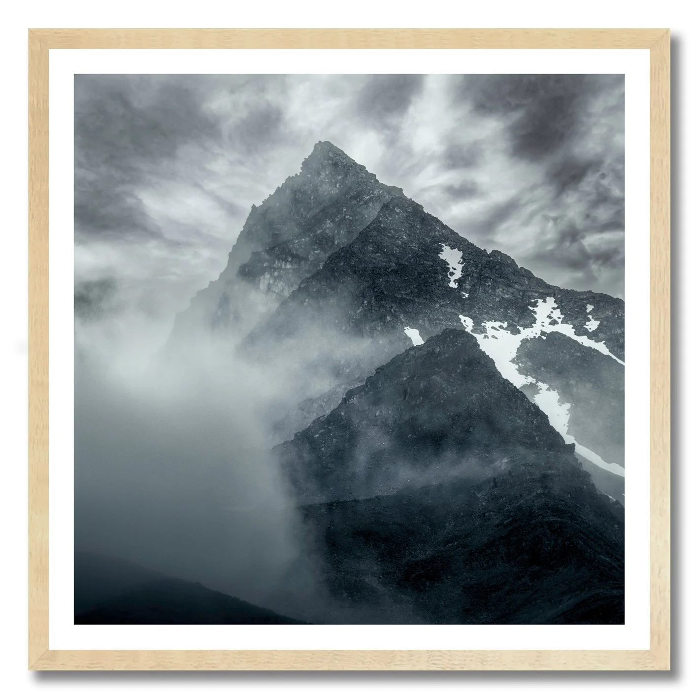 Mountain photograph emerging through mist and cloud with rugged alpine peak