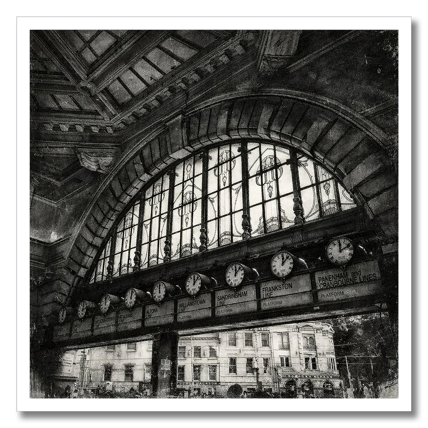 Black and white photograph of Flinders Street Station clocks under arched window