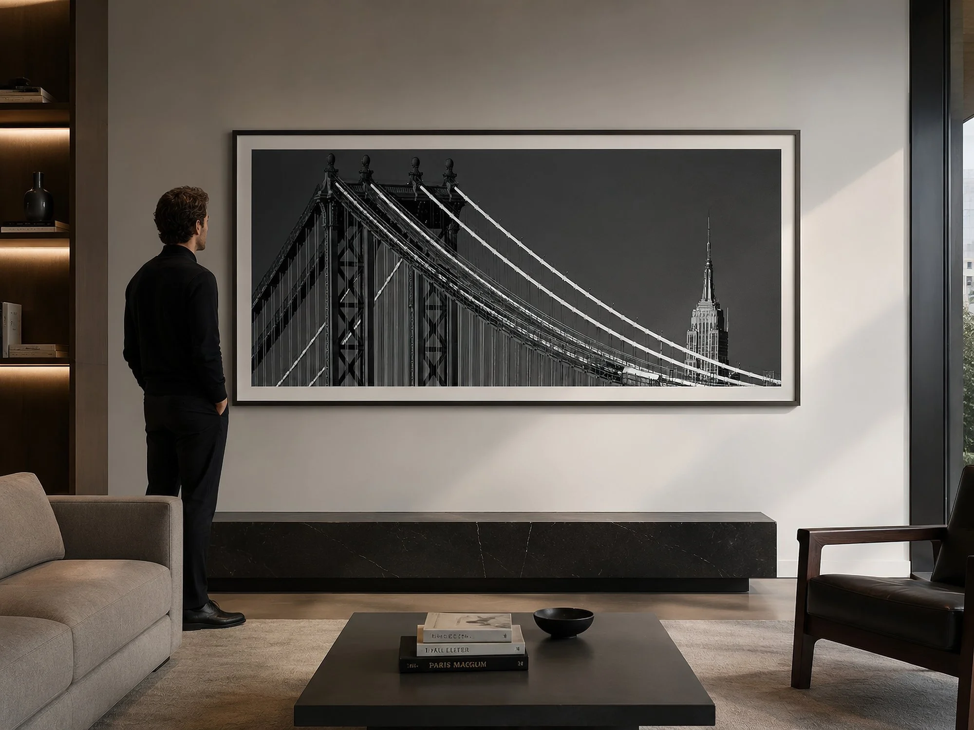 Modern interior with large framed black and white New York Steel photograph on wall with person viewing artwork.