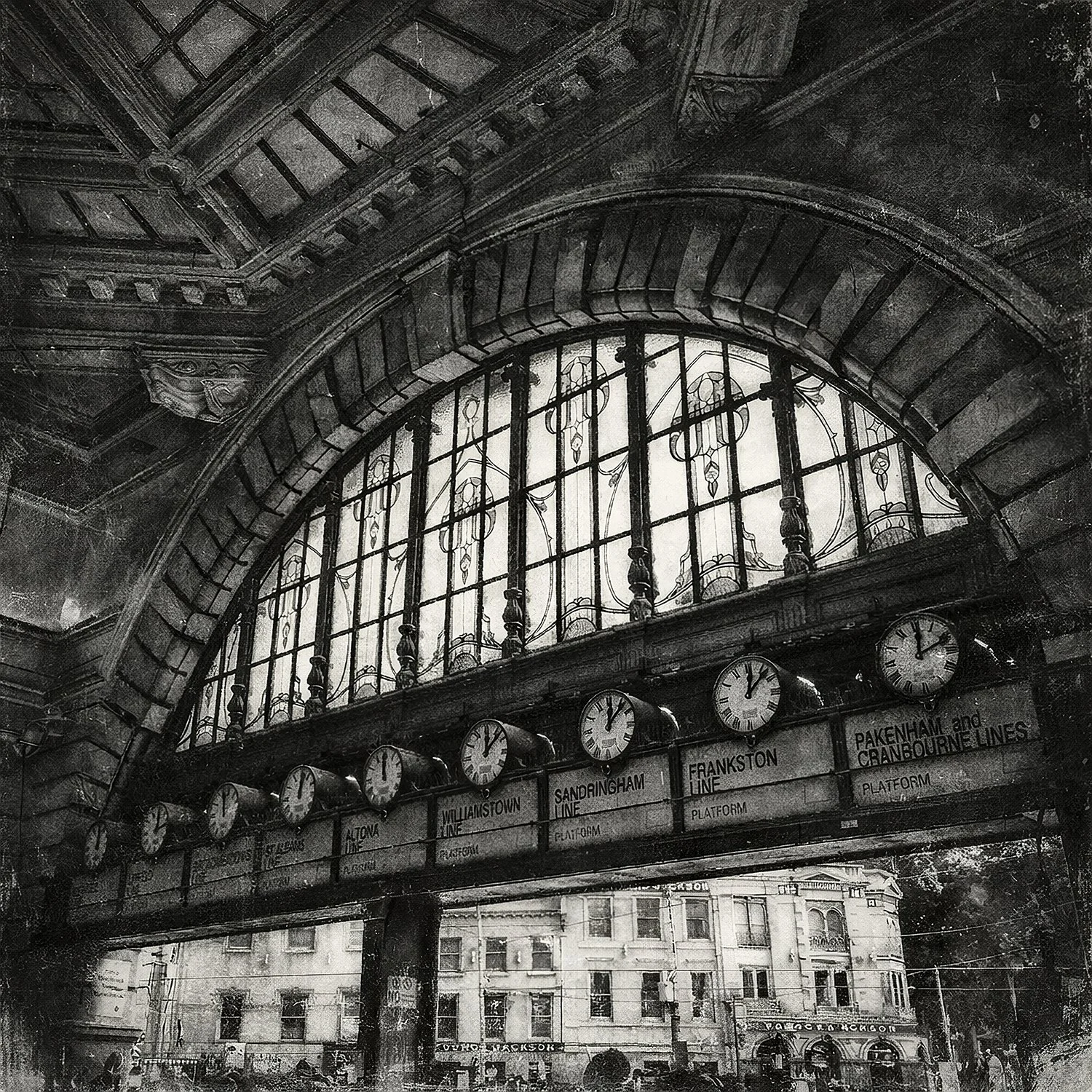 Black and white photograph of Flinders Street Station clocks under arched window