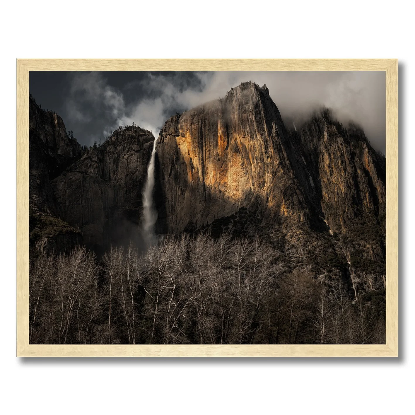 Yosemite Falls photograph with sunlit granite cliffs, mist and dark woodland in California