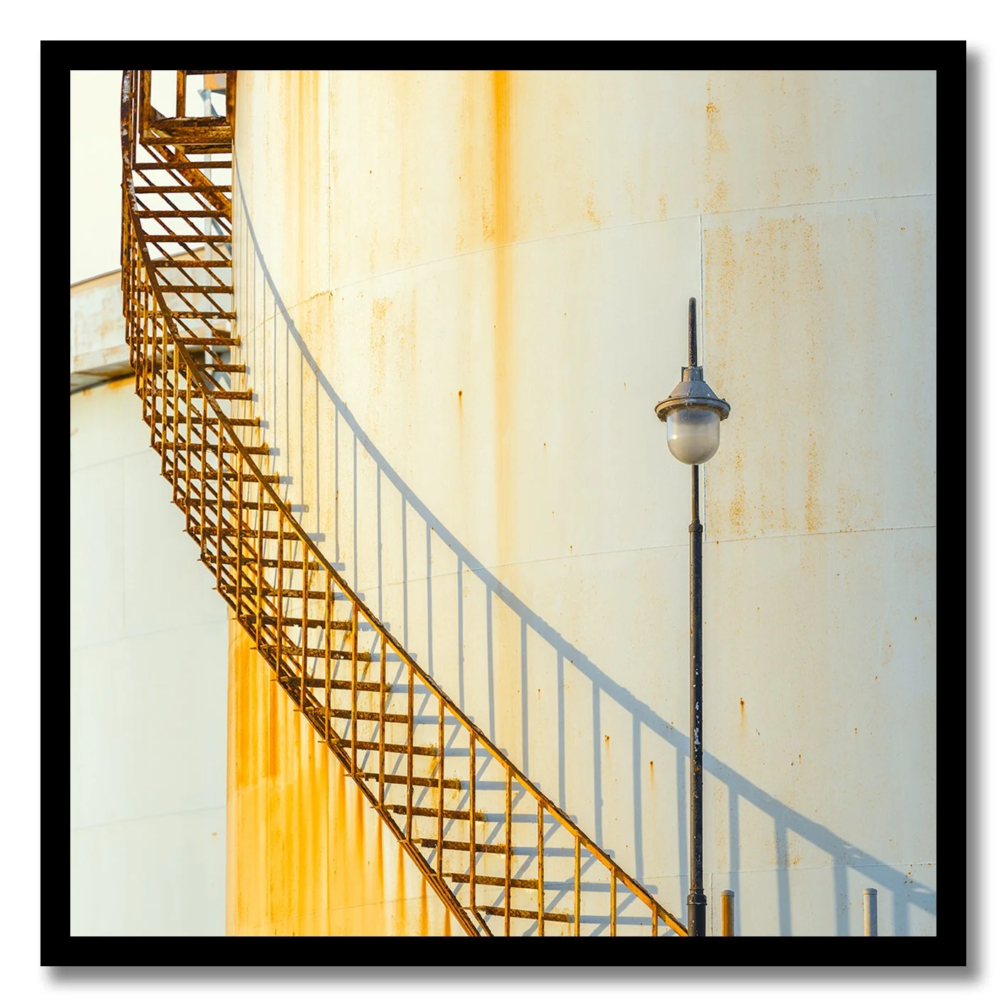 industrial staircase and lamp against rusted wall photograph