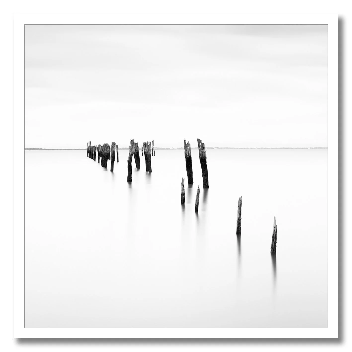 Black and white fine art photograph of old pier pylons at Tenby Point
