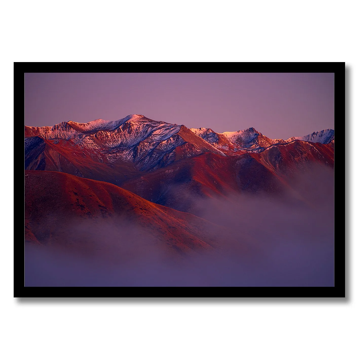 Mountain landscape photograph with alpenglow light on snowy peaks and misty valleys