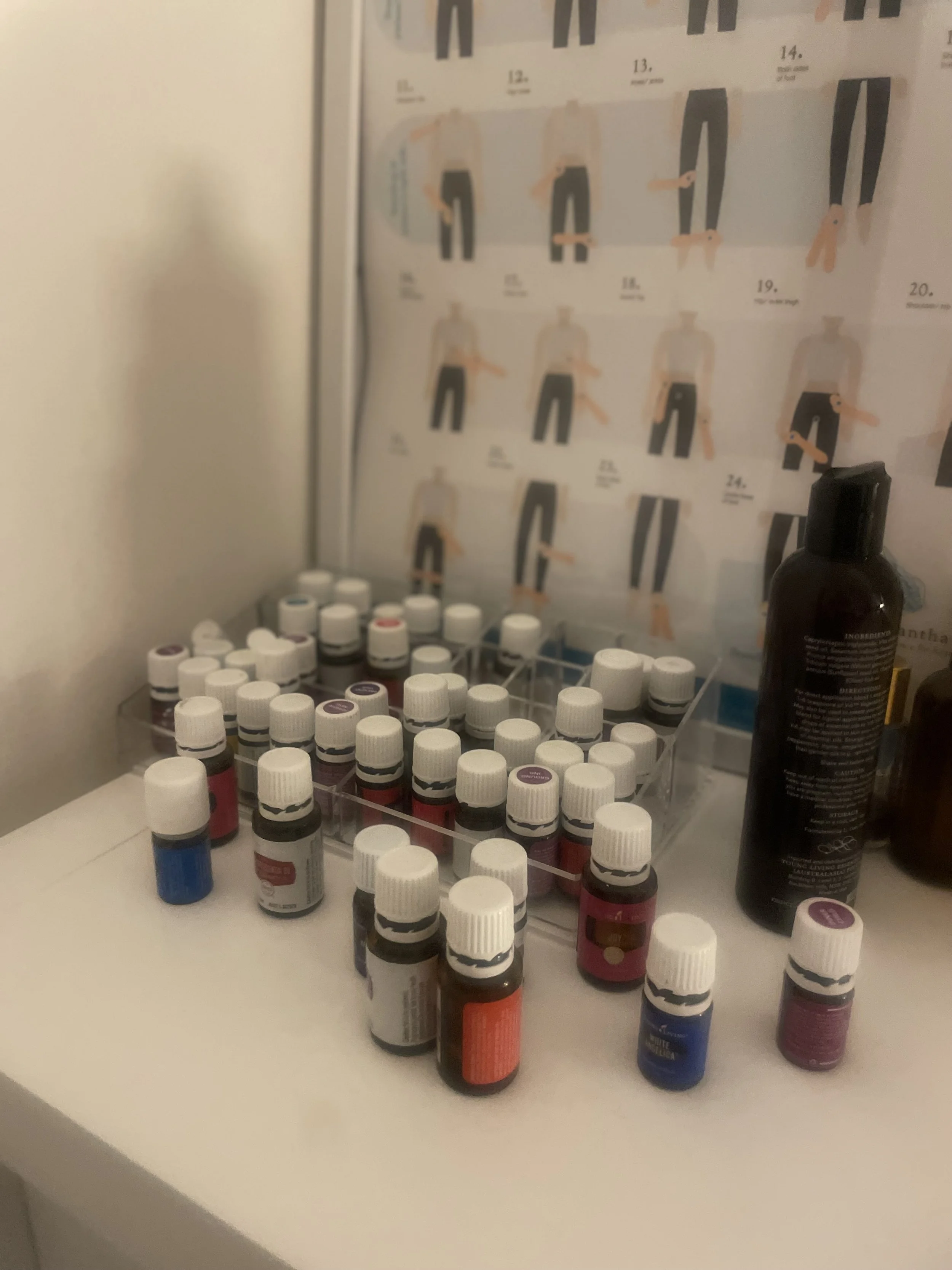 A collection of essential oils and bottles on a white surface, with a diagram of clothing sizes in the background.
