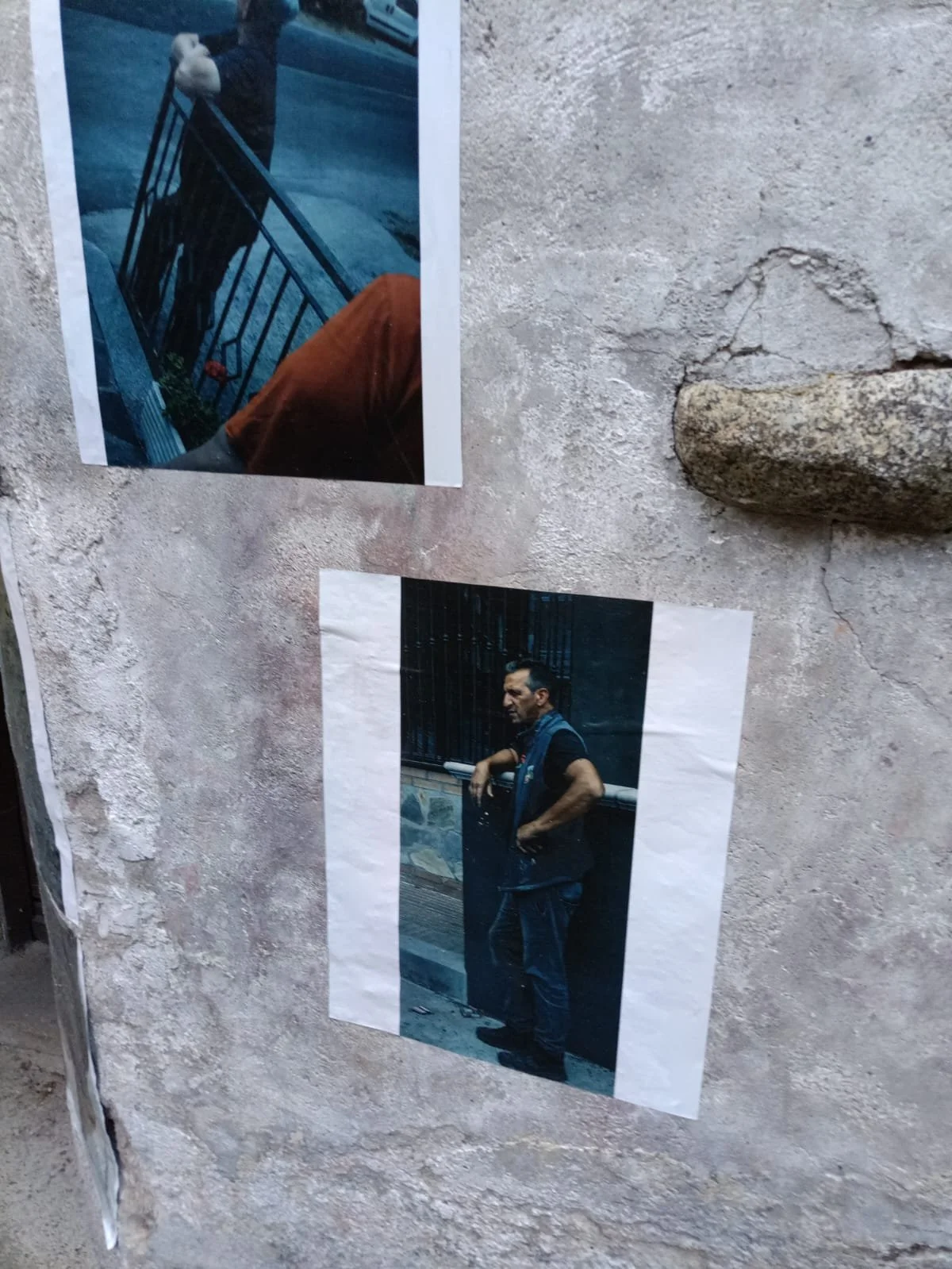 Due fotografie attaccate a una parete in pietra,  scattate da Davide Borowski