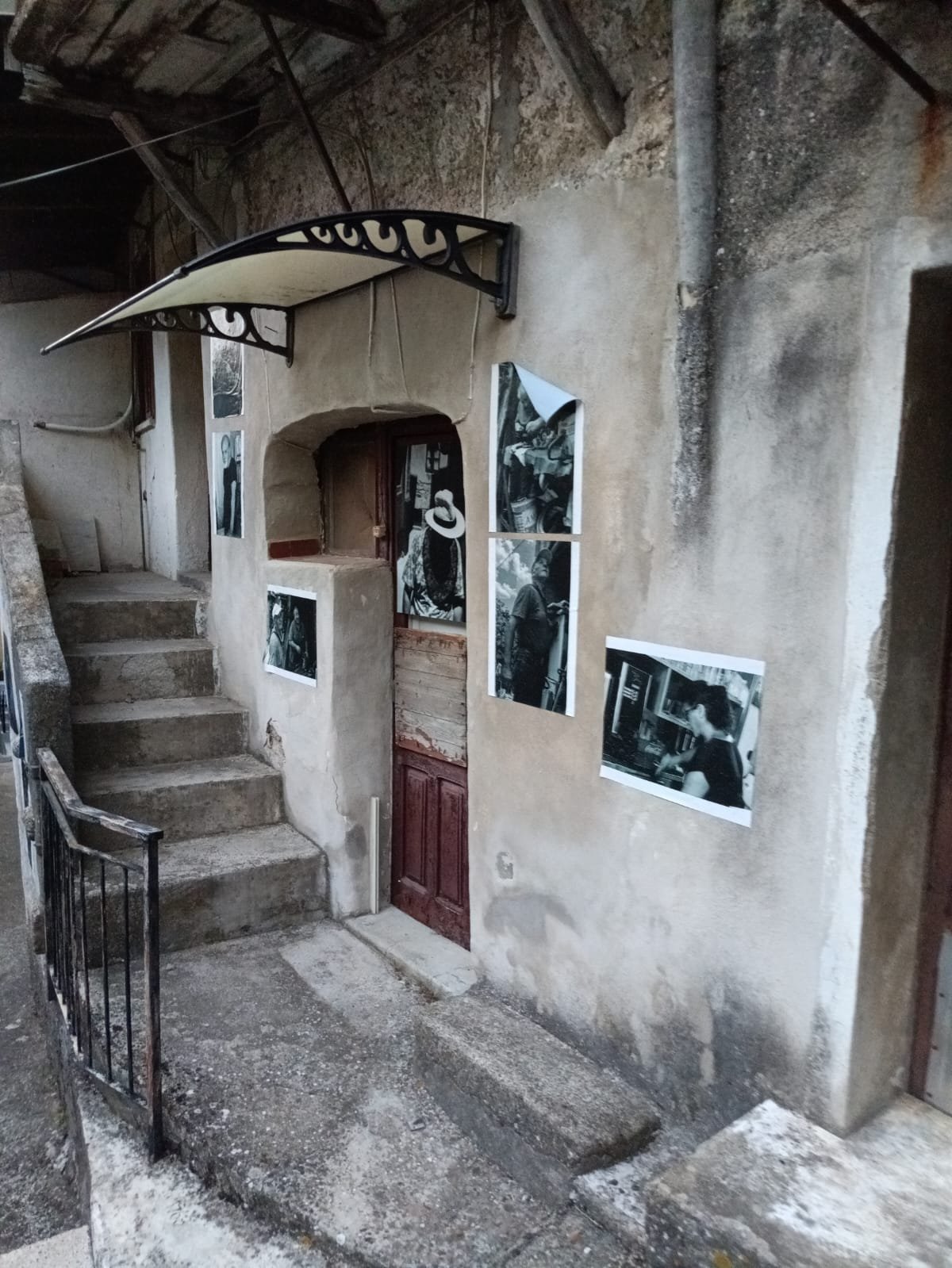 Parete in pietra con fotografie in bianco e nero attaccate, scattate da Davide Borowski