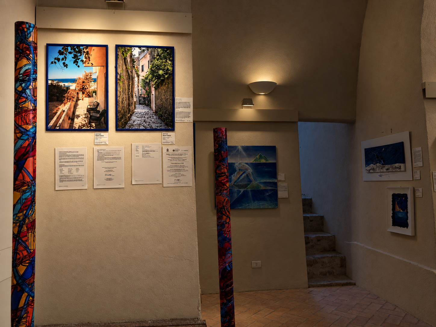 Mostra d'arte con fotografie e dipinti in una galleria
