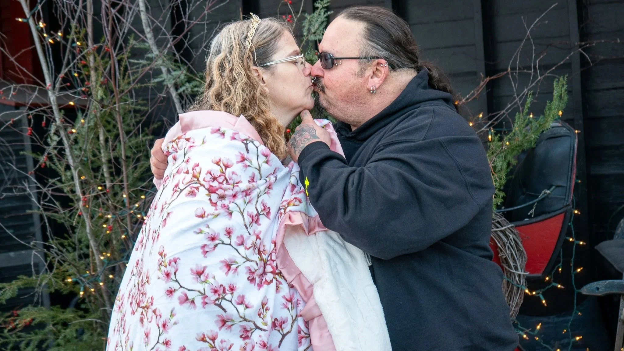 Ken is lifting MIchele's chin as he kisses her, after they have exchanged vows