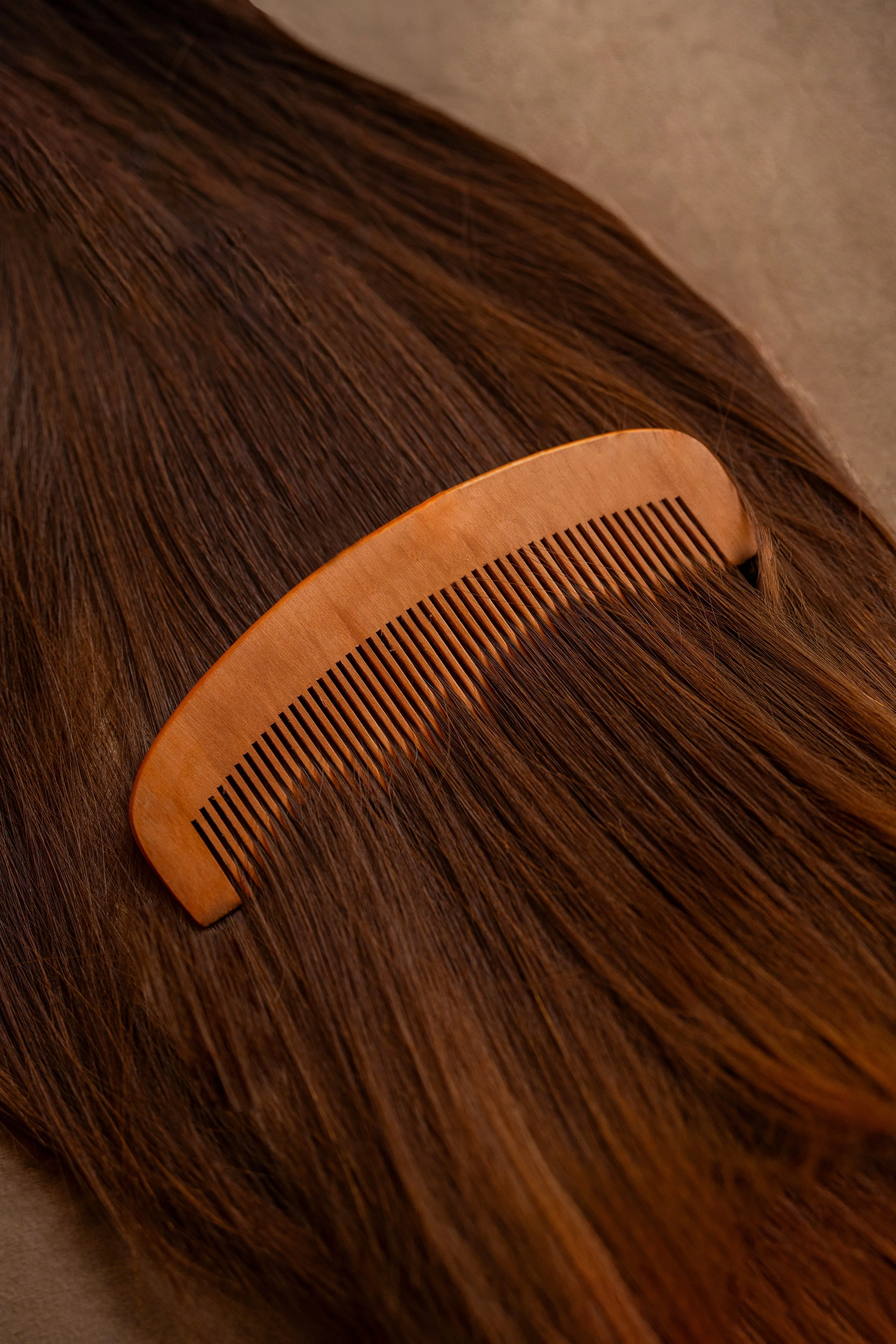 Cabelos castanhos com uma escova de madeira sobre eles.