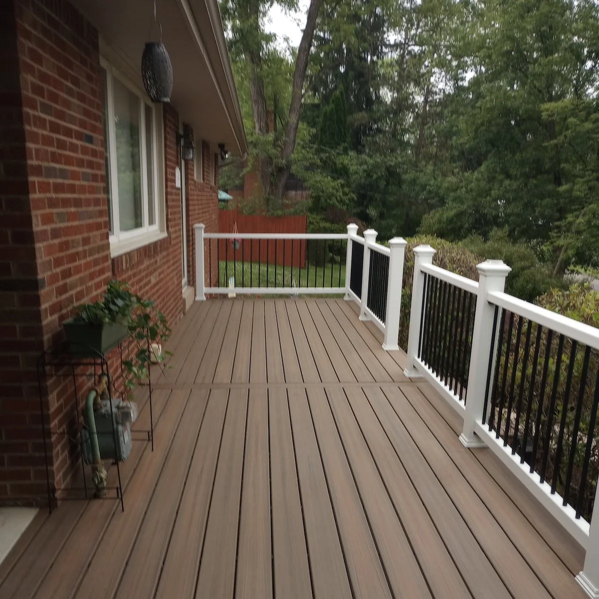 image of a rear garden deck with a white and black handrail